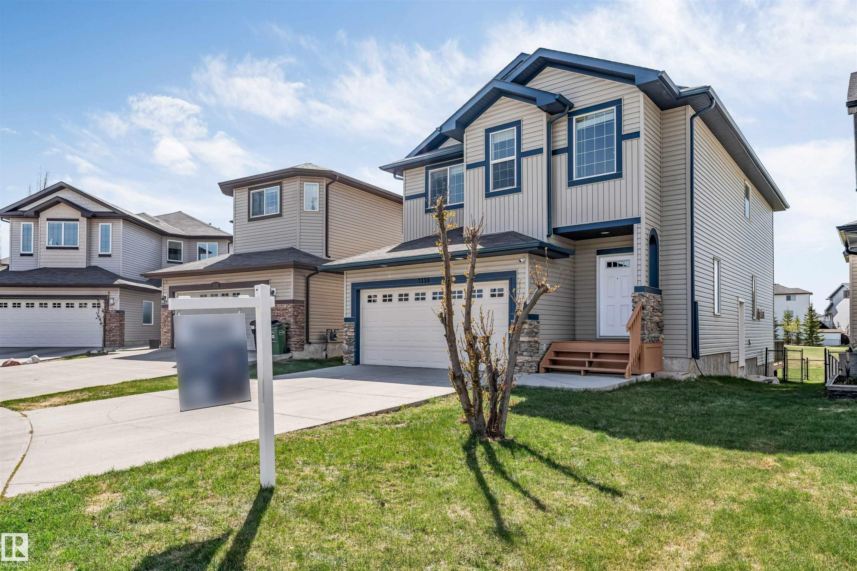 Two-story residence featuring light-colored siding with dark blue trim accents and a contrasting dark roof - 2138 32B Street, Edmonton, AB - Outdoor With Facade