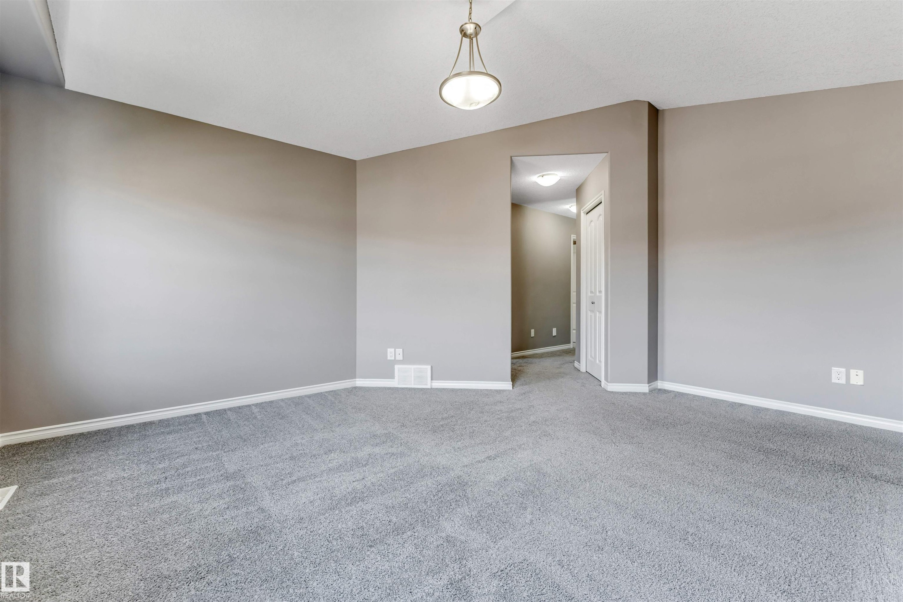 Spacious room featuring neutral grey walls and a light grey carpeted floor - 2138 32B Street, Edmonton, AB - Indoor Photo Showing Other Room