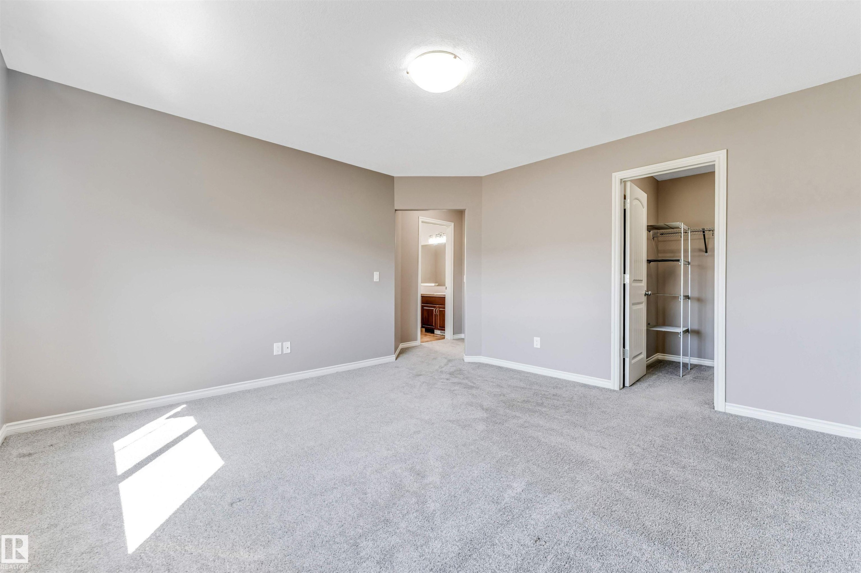 Spacious room featuring neutral-toned walls, light gray carpeting, and white trim - 2138 32B Street, Edmonton, AB - Indoor Photo Showing Other Room