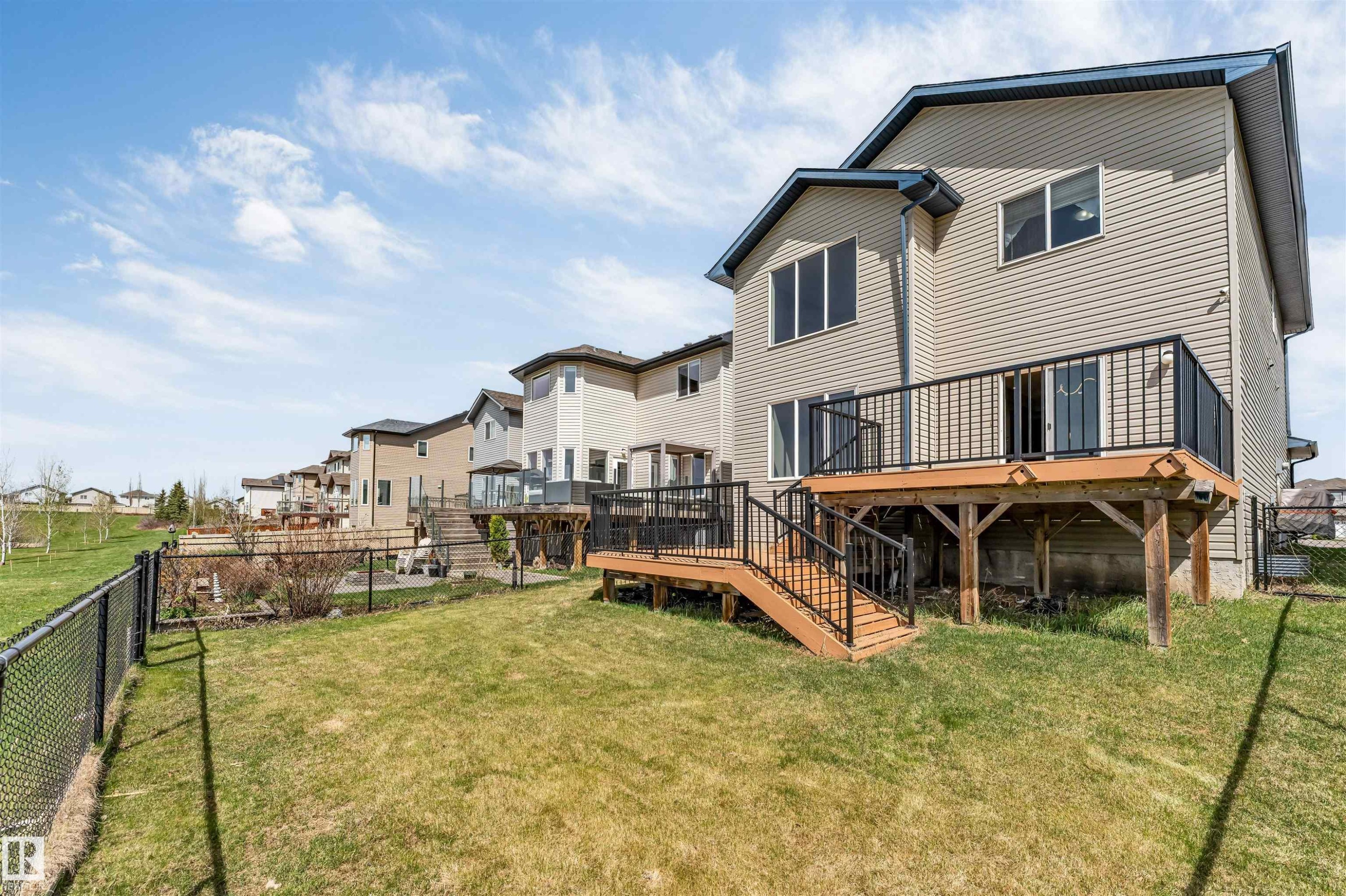 Rear exterior featuring a multi-level wooden deck with black metal railings and stairs - 2138 32B Street, Edmonton, AB - Outdoor With Deck Patio Veranda