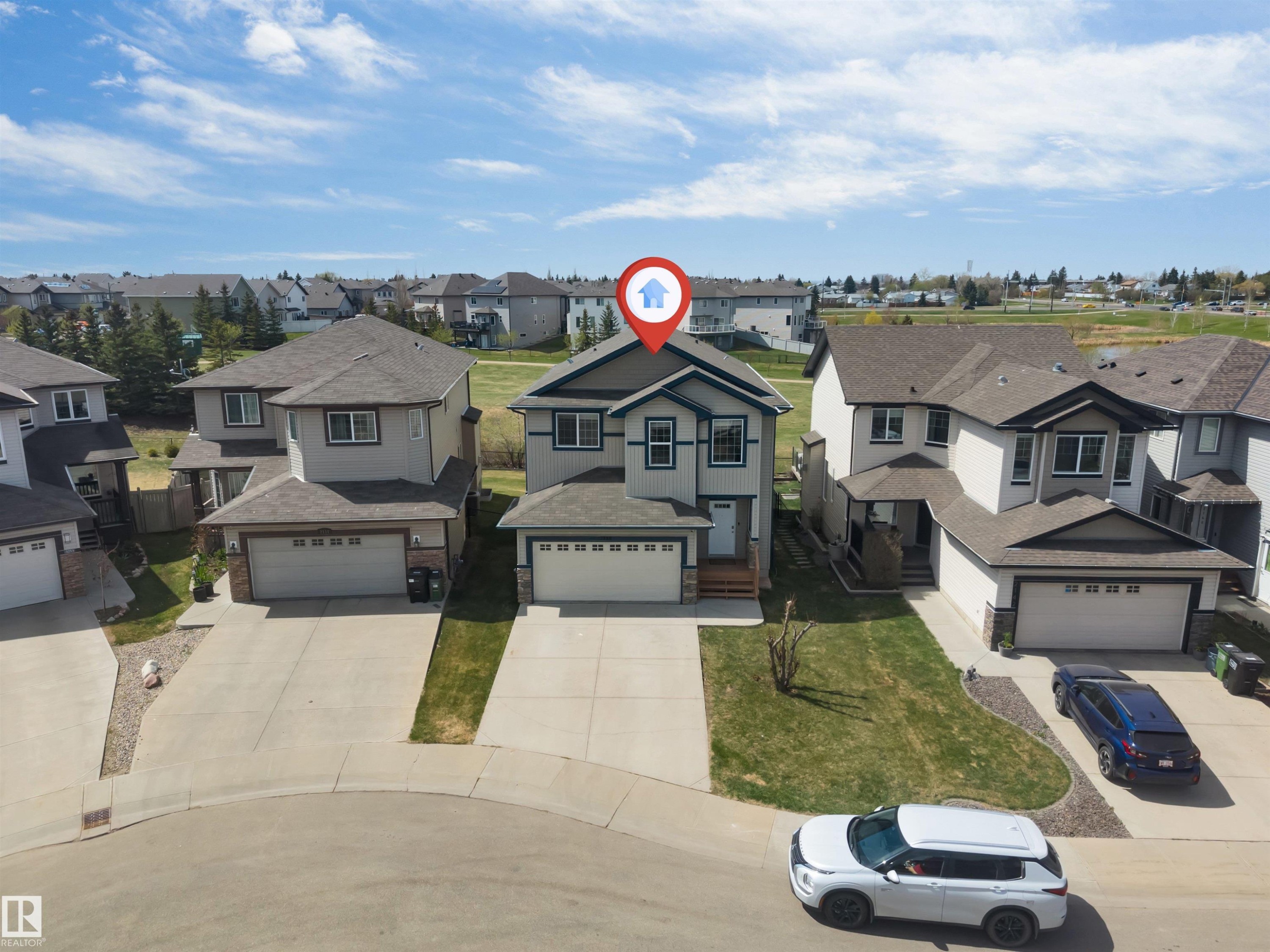 Contemporary two-story residence featuring a front-facing attached garage, concrete driveway, and a front lawn with a decorative tree - 2138 32B Street, Edmonton, AB - Outdoor With Facade