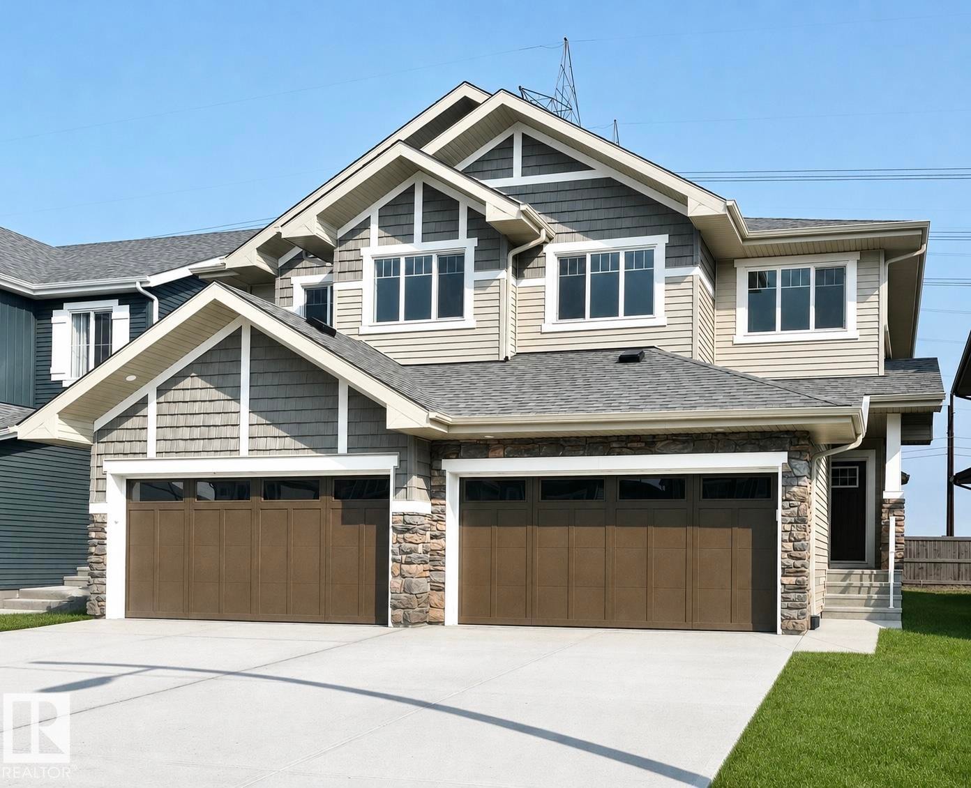 Craftsman-style facade featuring multiple gables, horizontal siding, shake siding, stone accents, and a two-car garage with panel doors - 19632 29 Avenue, Edmonton, AB - Outdoor With Facade
