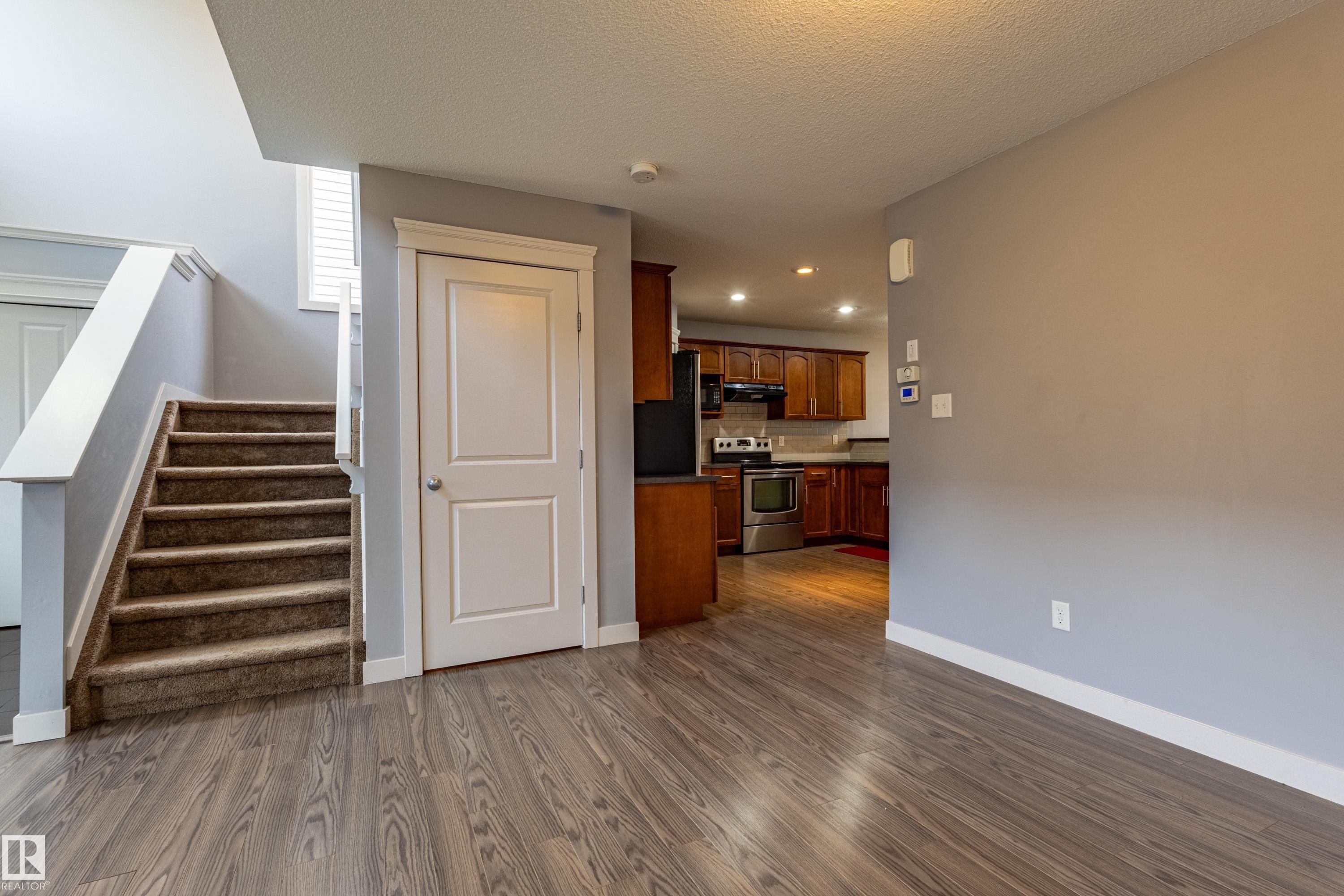Wood-finish flooring throughout the main level - 17715 6 Avenue, Edmonton, AB - Indoor