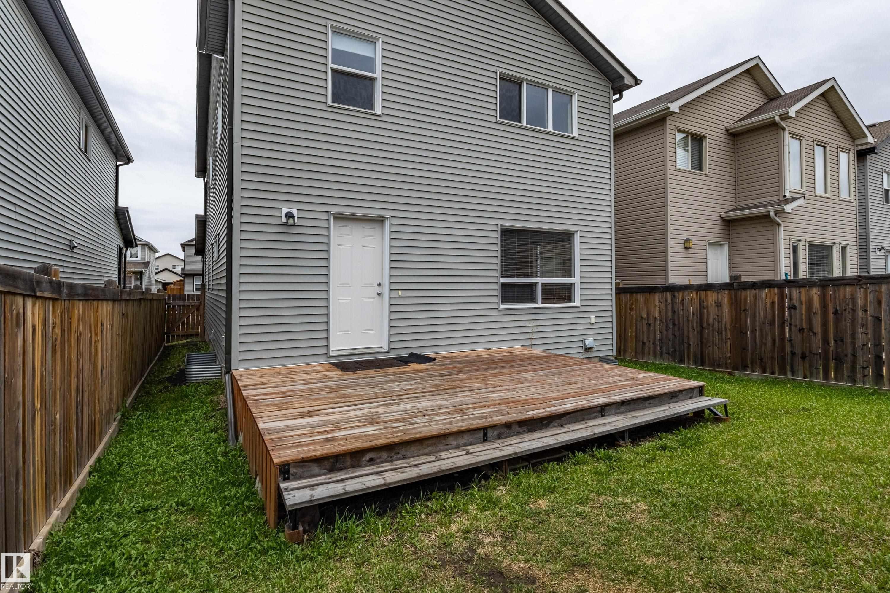 Private backyard featuring a wood deck and a level lawn area - 17715 6 Avenue, Edmonton, AB - Outdoor With Exterior
