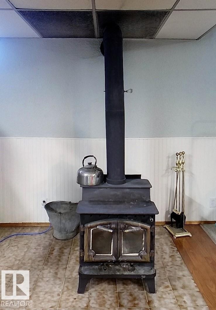 Cast iron wood-burning stove with dual glass doors - 7126 4A Ave, Edson, AB - Indoor Photo Showing Other Room