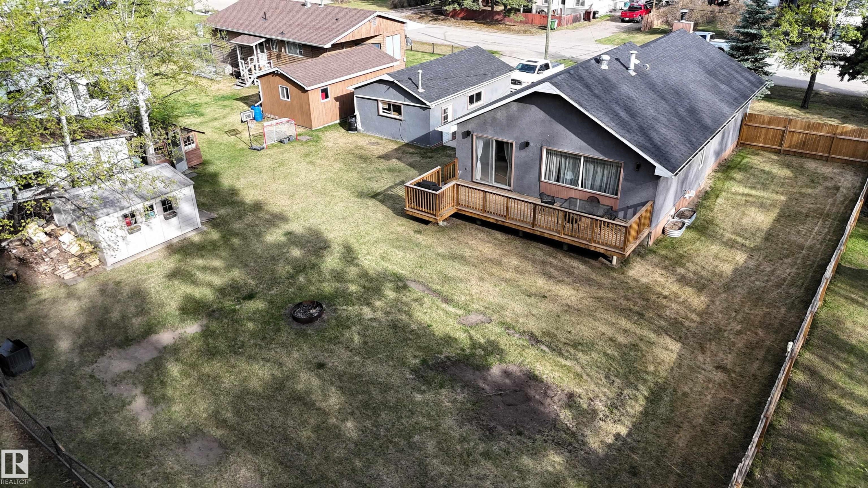 Single-story residence featuring a gray exterior and a wooden deck - 7126 4A Ave, Edson, AB - Outdoor