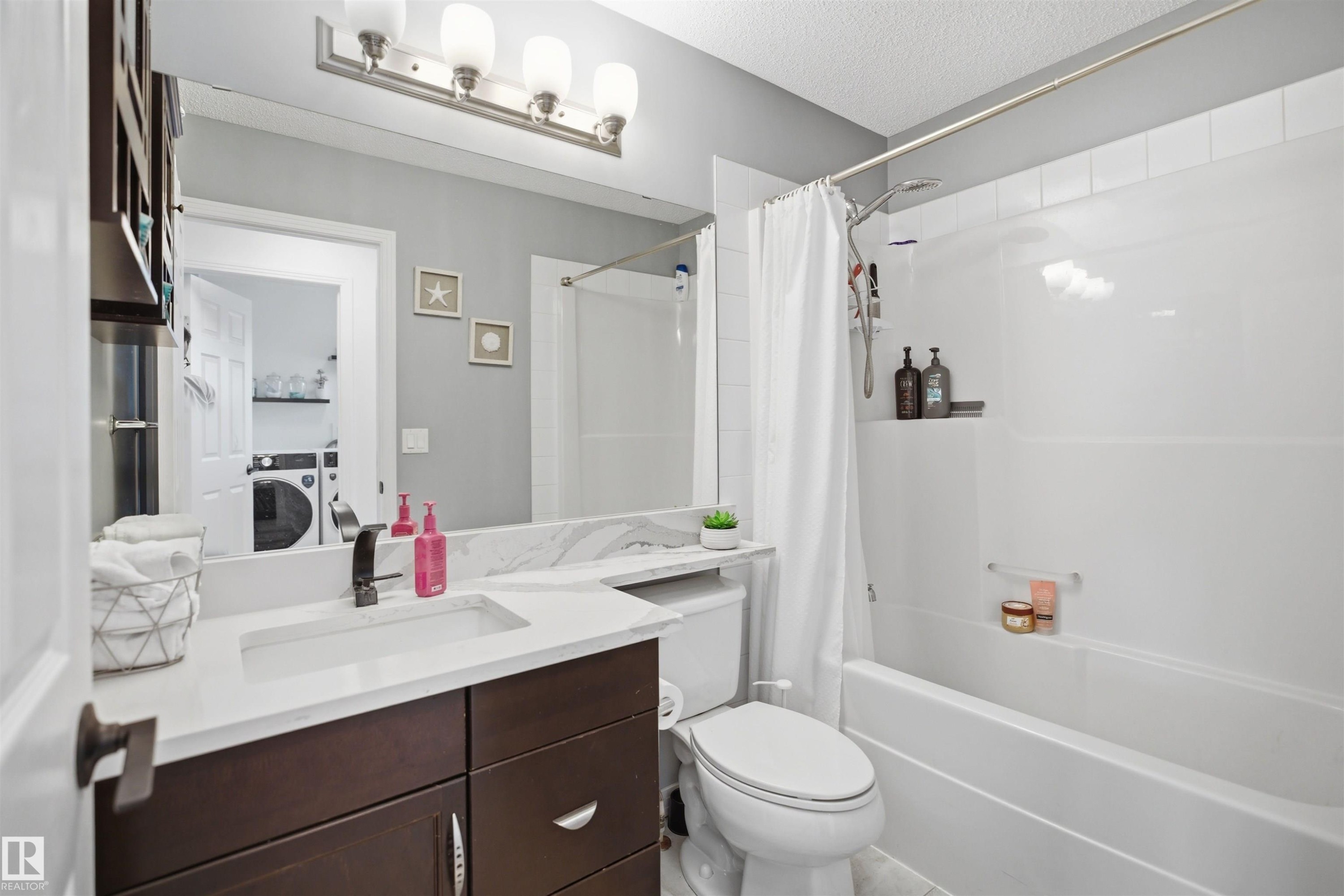 Bathroom featuring a white vanity with a rectangular undermount sink and dark wood-finish cabinetry - 1453 Hays Way Nw, Edmonton, AB - Indoor Photo Showing Bathroom