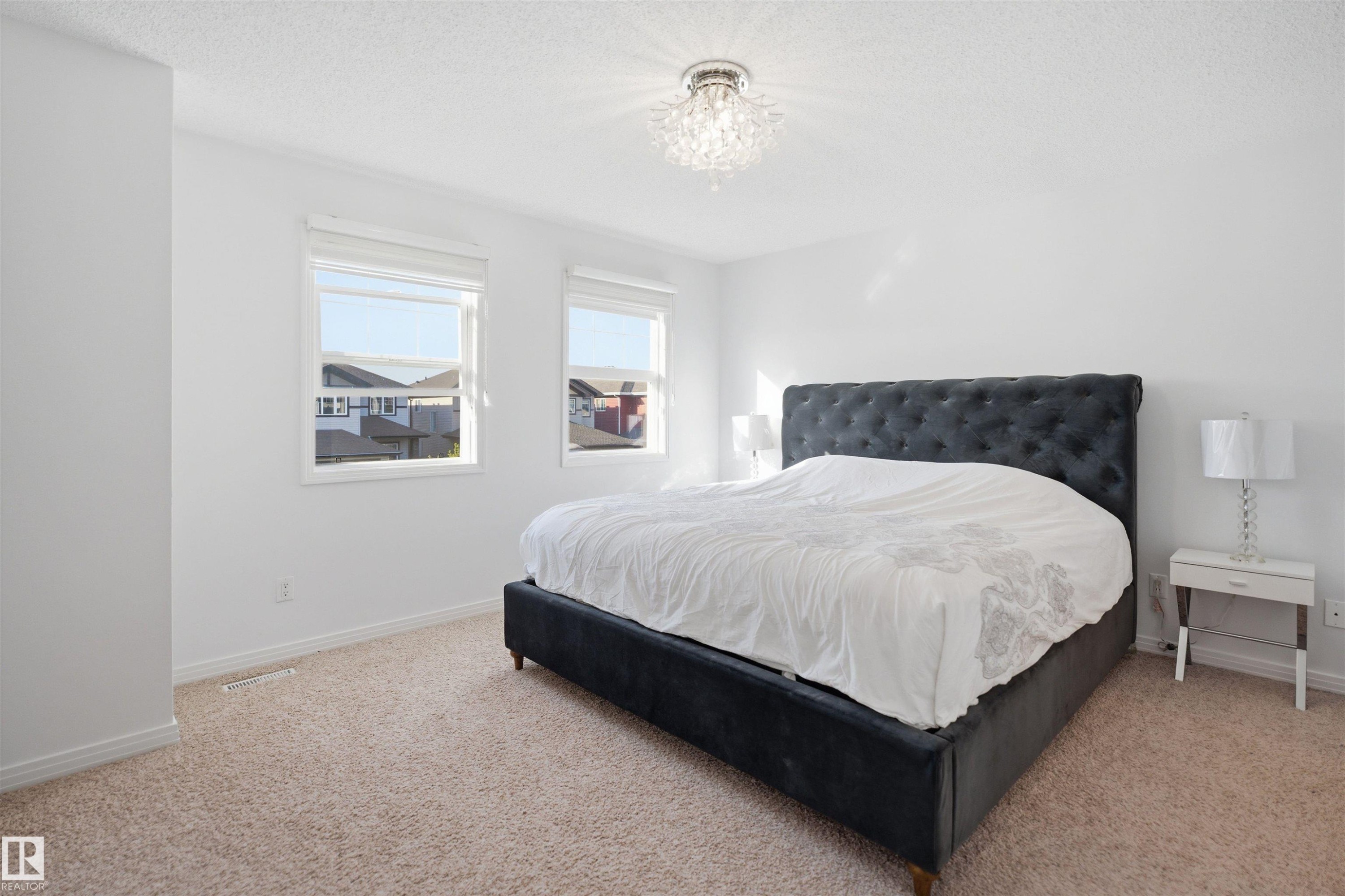 Carpeted bedroom featuring white walls and two windows - 1453 Hays Way Nw, Edmonton, AB - Indoor Photo Showing Bedroom