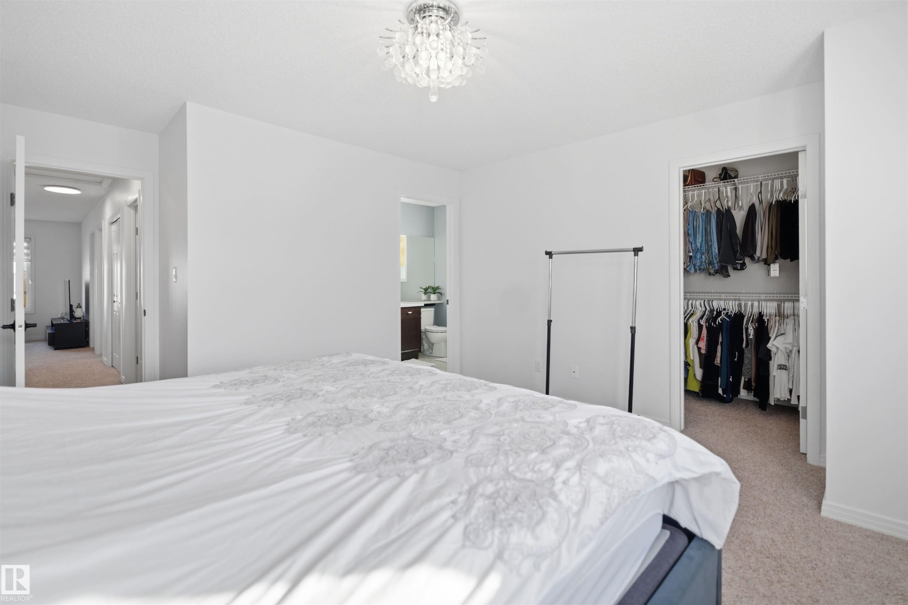 Carpeted bedroom with a decorative ceiling light fixture - 1453 Hays Way Nw, Edmonton, AB - Indoor Photo Showing Bedroom