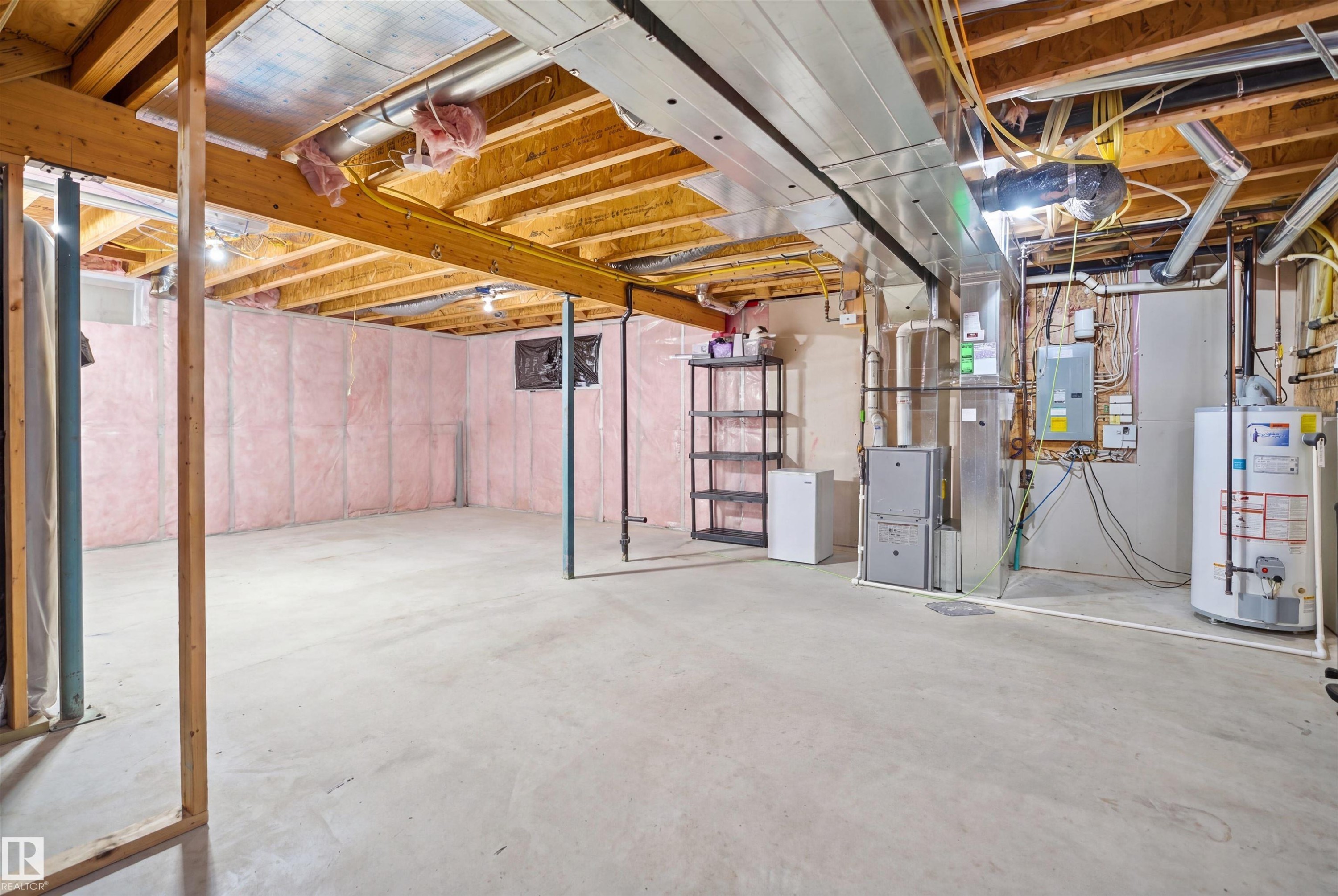 Spacious unfinished basement featuring exposed wood joists, concrete flooring, pink insulation, and visible HVAC ductwork - 1453 Hays Way Nw, Edmonton, AB - Indoor Photo Showing Basement