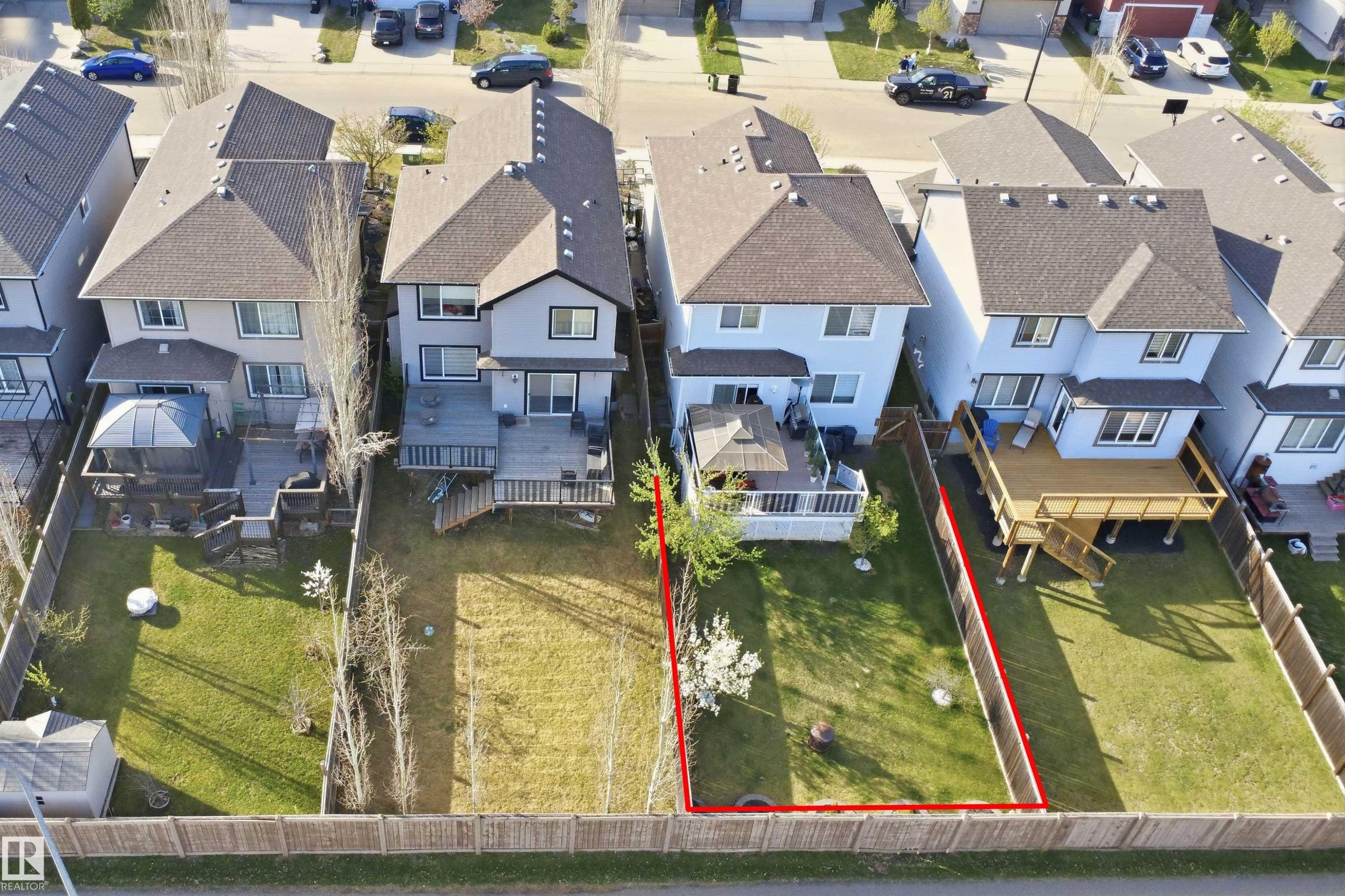 Expansive rear yard featuring a manicured lawn, established landscaping, and wooden privacy fencing - 1453 Hays Way Nw, Edmonton, AB - Outdoor With View