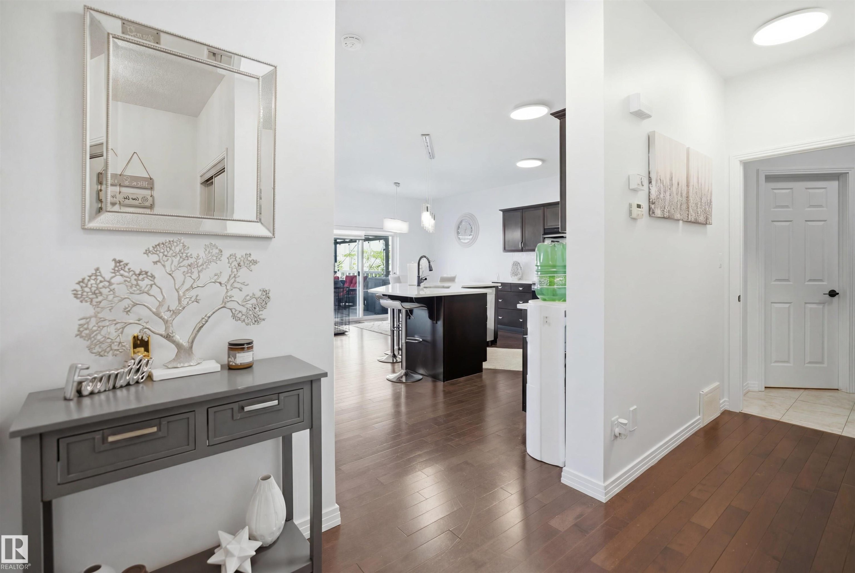 Foyer featuring wood-finish flooring, white baseboards, a paneled interior door, and recessed lighting - 1453 Hays Way Nw, Edmonton, AB - Indoor Photo Showing Other Room