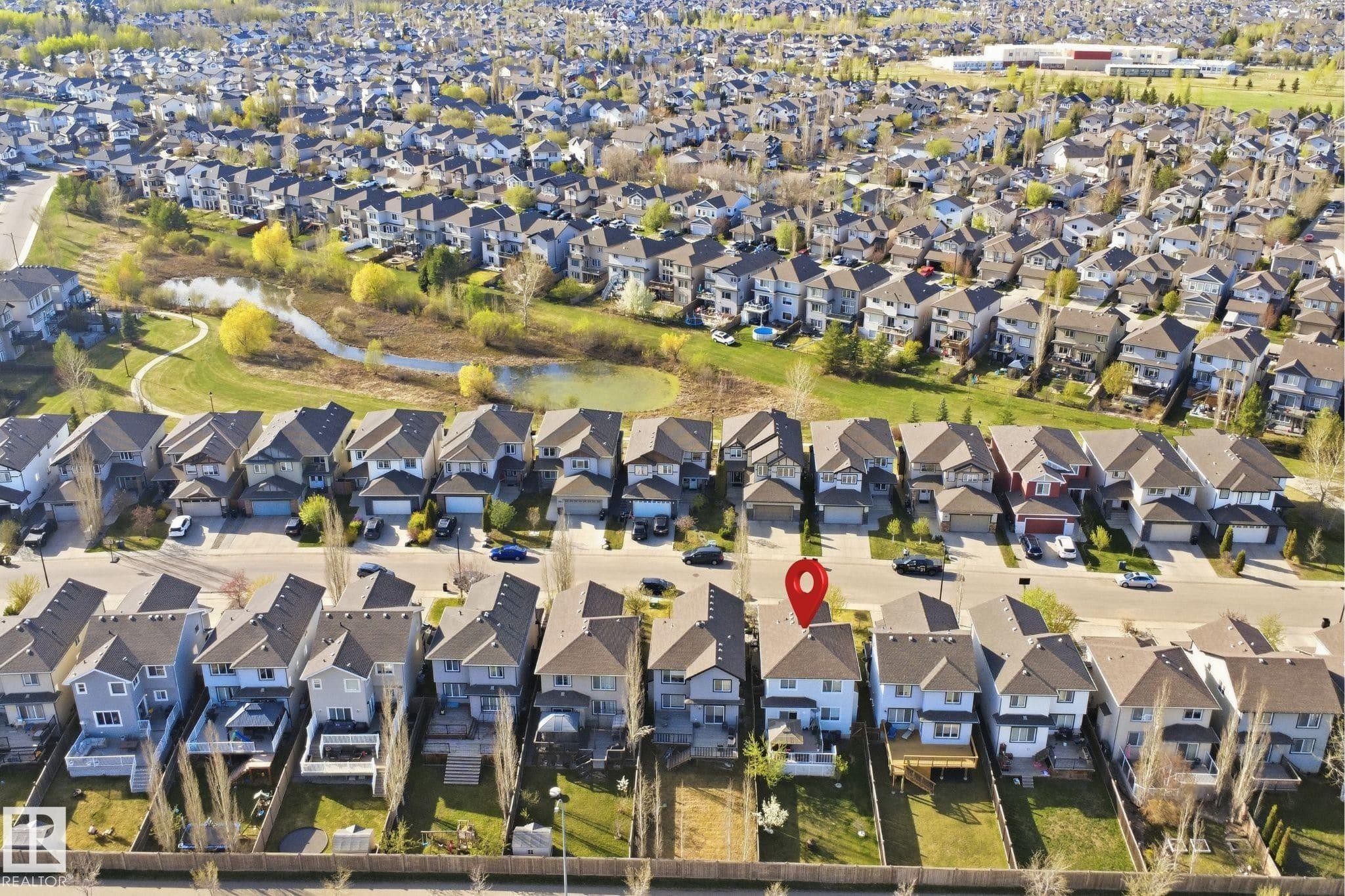Aerial perspective showcasing a residential area with a prominent natural pond and green space - 1453 Hays Way Nw, Edmonton, AB - Outdoor With View