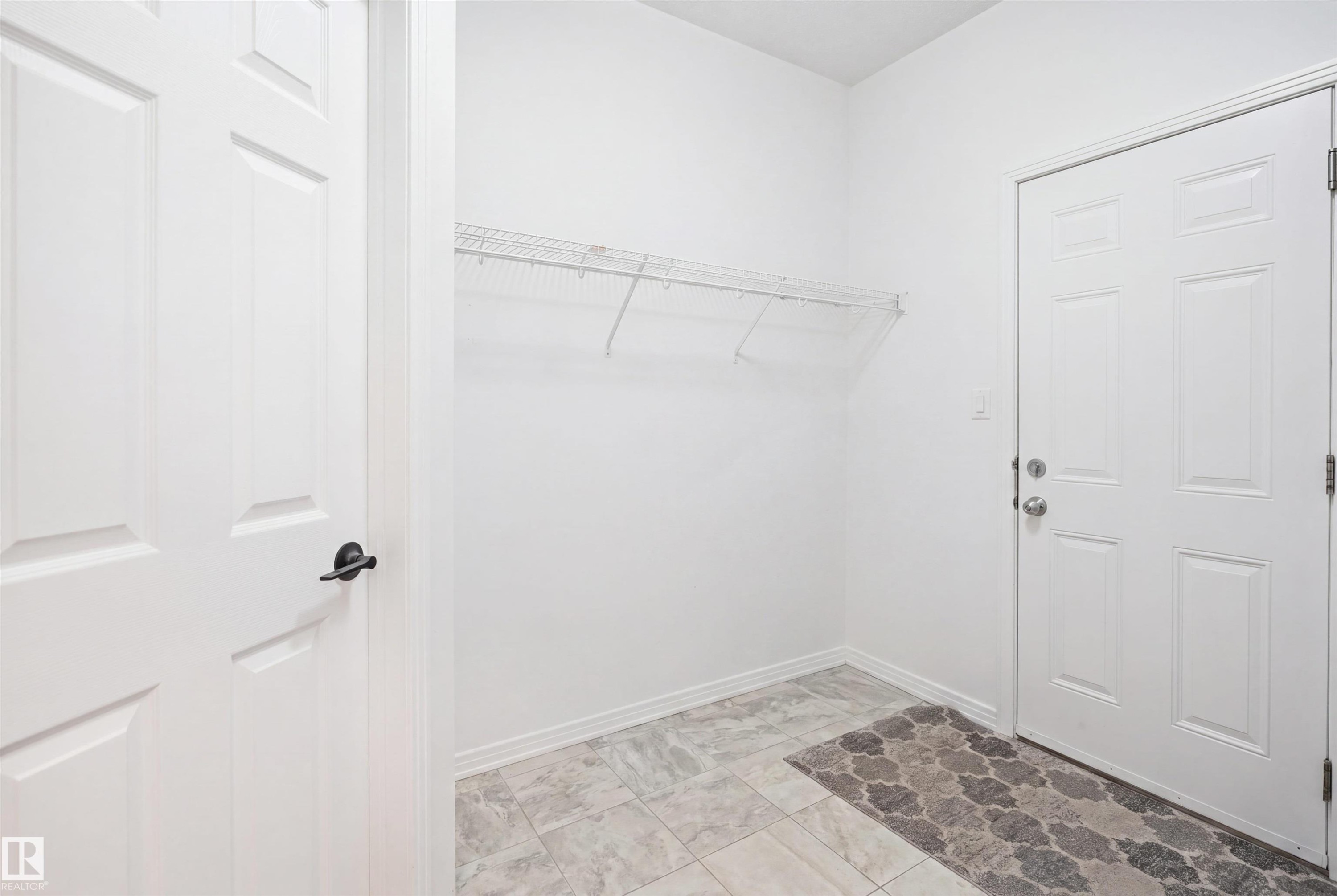 Entryway featuring a white paneled door, black hardware, and wire shelving - 1453 Hays Way Nw, Edmonton, AB - Indoor
