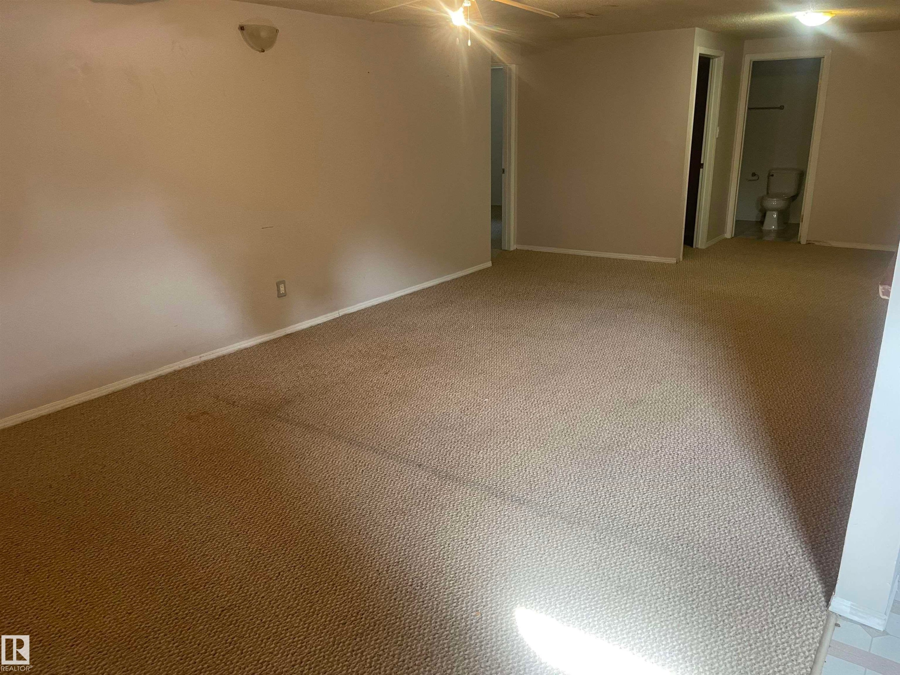 This space features carpeted flooring, neutral wall colors, and ceiling-mounted light fixtures - 2629 129A Avenue, Edmonton, AB - Indoor Photo Showing Other Room