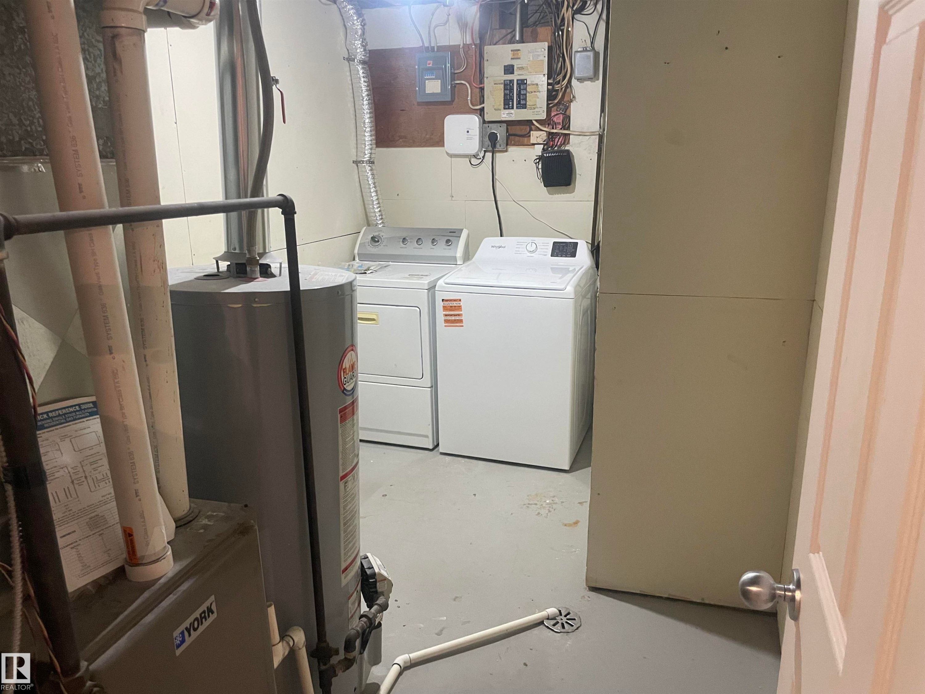 The utility area features a water heater, a washer, and a dryer - 2629 129A Avenue, Edmonton, AB - Indoor Photo Showing Laundry Room