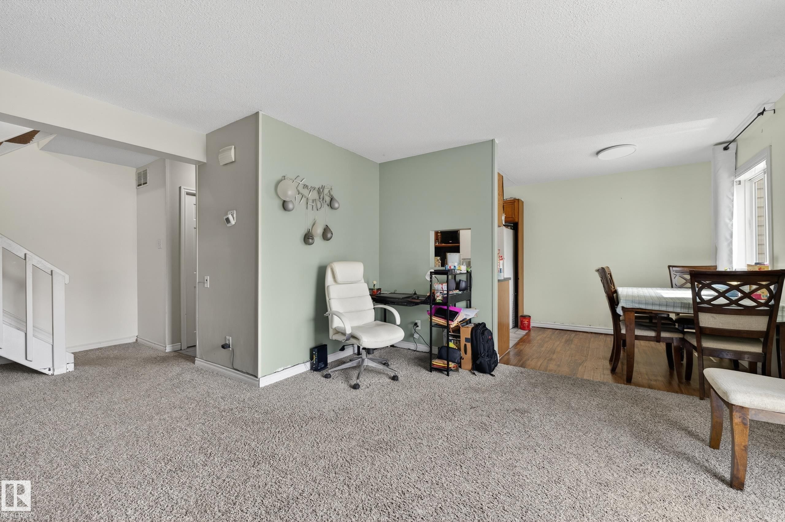 Open-concept living area featuring light gray carpeting and a neutral wall palette - 26E Meadowlark Village, Edmonton, AB - Indoor