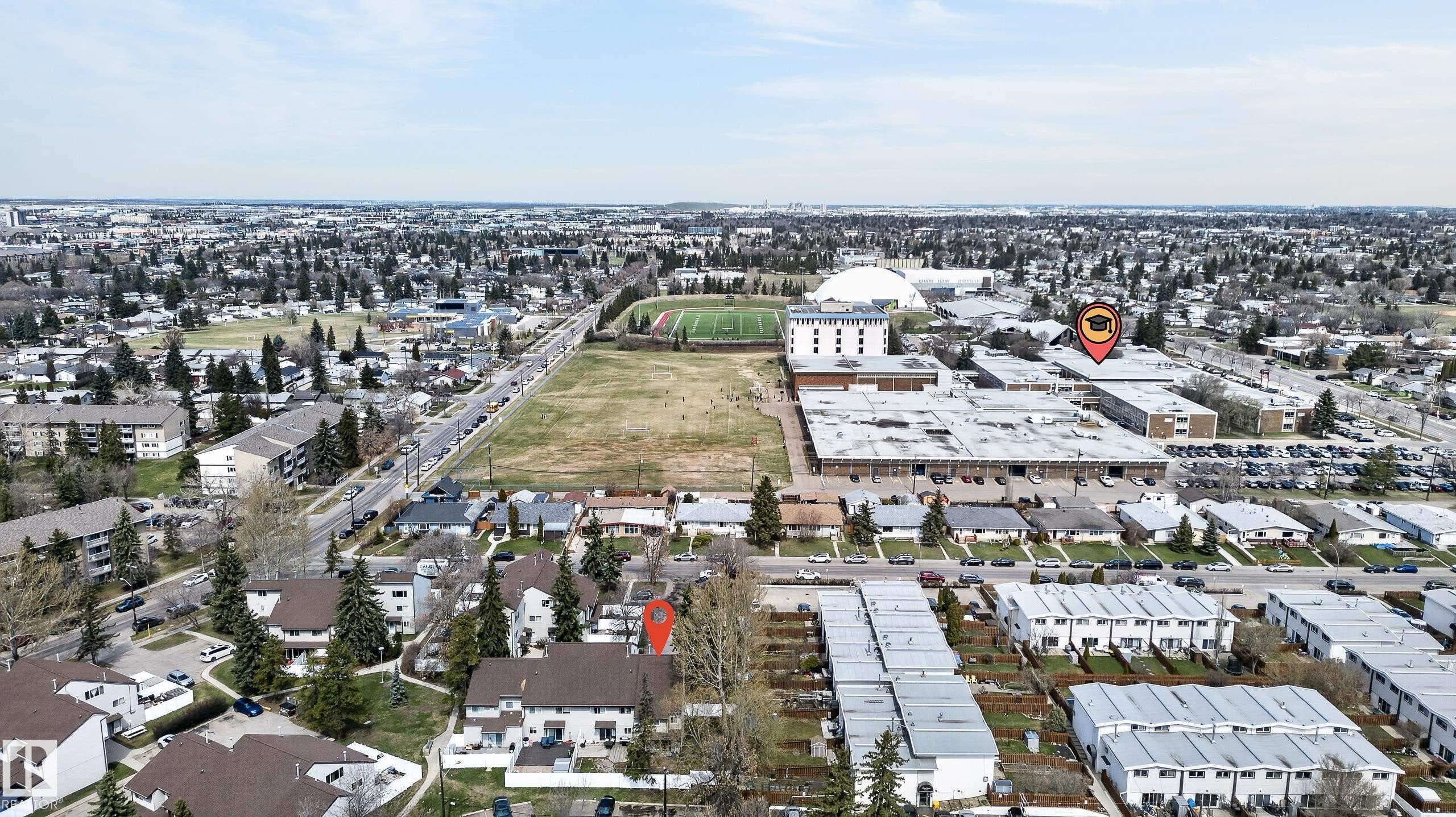 Aerial perspective showcasing a dense urban and suburban landscape with residential housing, commercial buildings, and open green spaces - 26E Meadowlark Village, Edmonton, AB - Outdoor With View