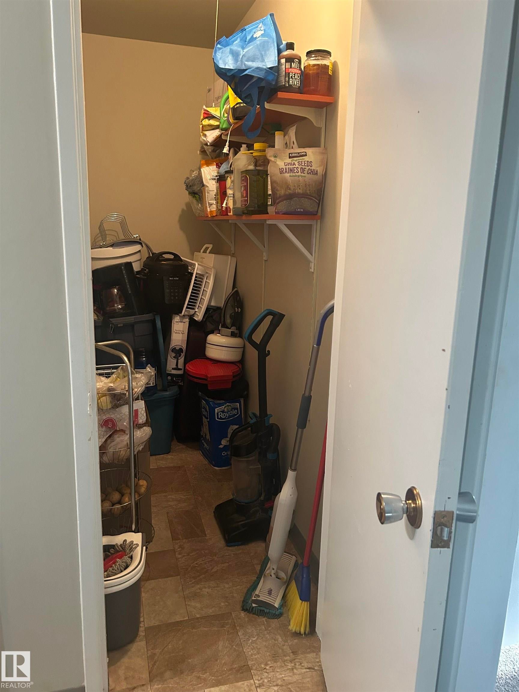 Compact storage closet featuring light-toned walls and durable vinyl flooring - 204 10811 115 Street, Edmonton, AB - Indoor