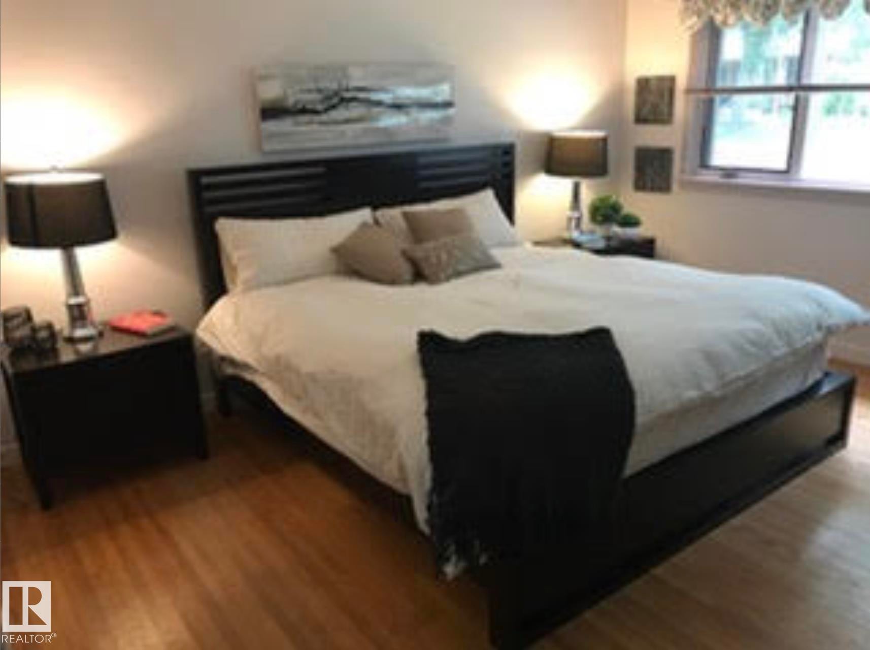 Hardwood-style flooring throughout, featuring a window with a valance, and a built-in headboard - 9126 117 Street, Edmonton, AB