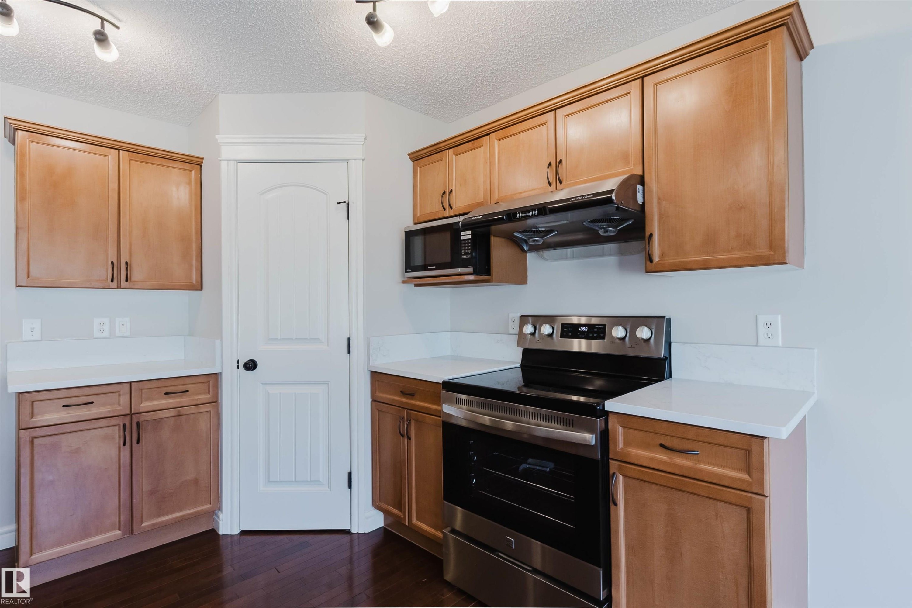 Kitchen featuring wood cabinetry, white countertops, a stainless steel range, and a built-in microwave - 1140 115 Street, Edmonton, AB - Indoor Photo Showing Kitchen