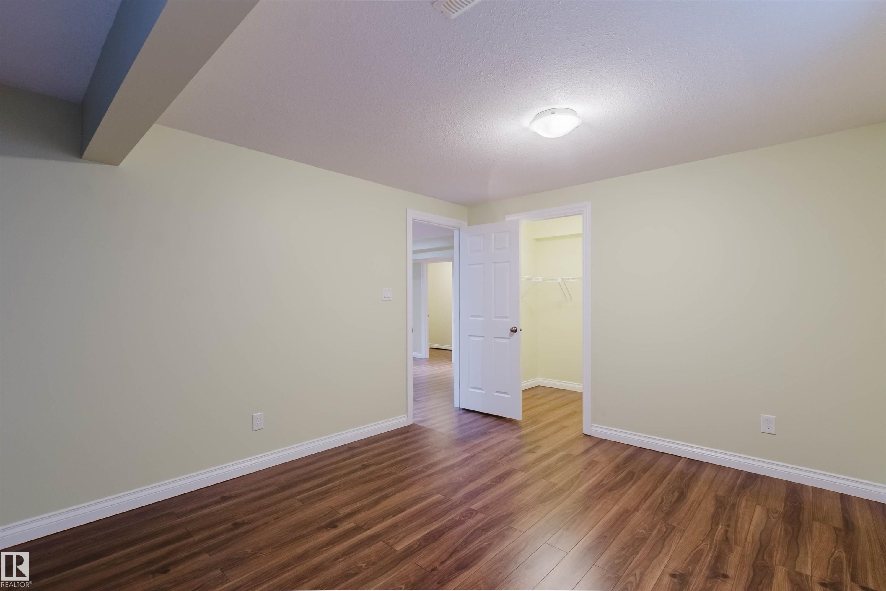 Bright interior space featuring wood-finish flooring, light-toned walls, and white trim - 1140 115 Street, Edmonton, AB - Indoor Photo Showing Other Room