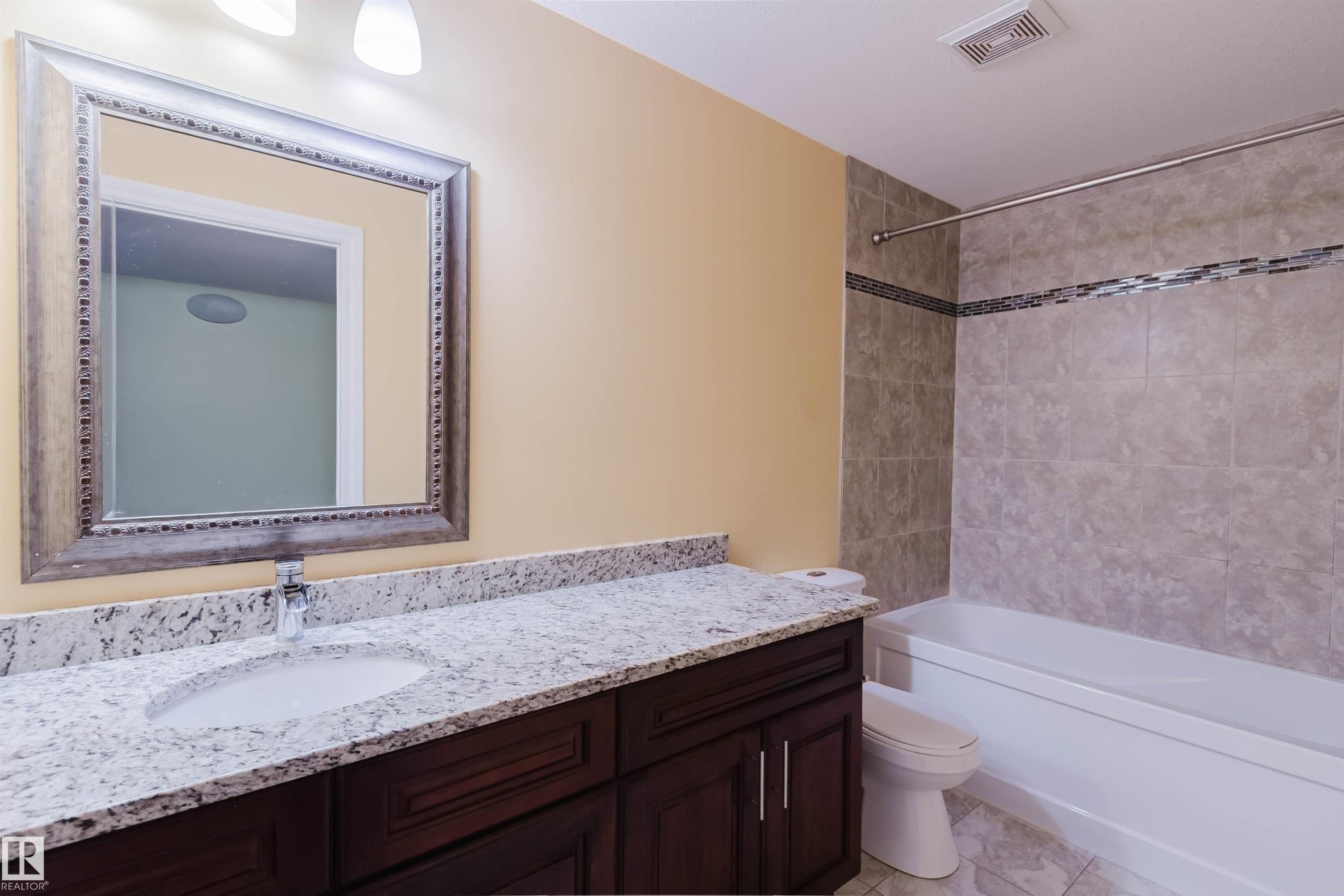 Bathroom featuring a dark wood-finish vanity with a white countertop and integrated sink - 1140 115 Street, Edmonton, AB - Indoor Photo Showing Bathroom