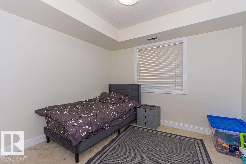 Interior space featuring neutral wall paint, carpet flooring, a window with blinds, and white trim - 214 13005 140 Avenue, Edmonton, AB - Indoor Photo Showing Bedroom