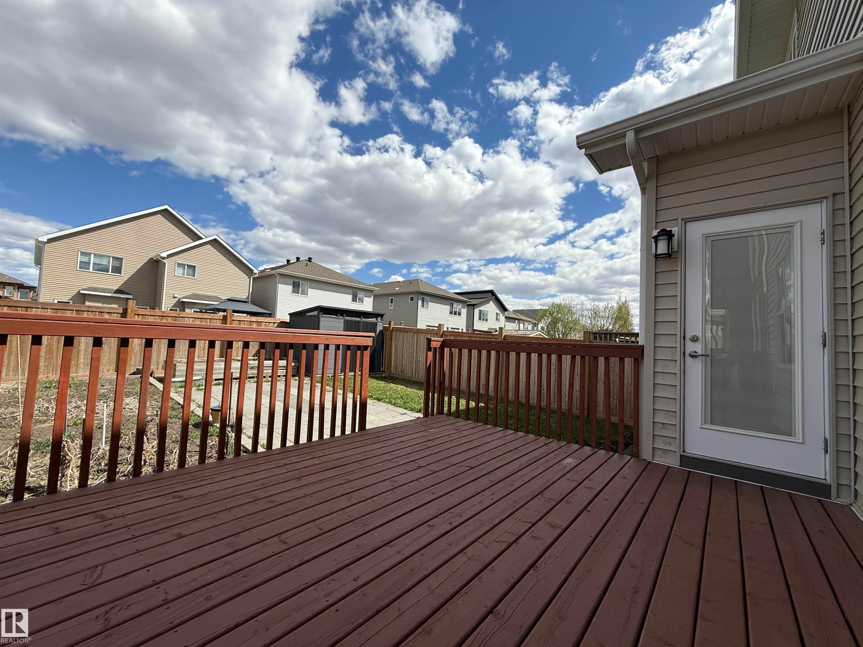 Spacious wooden deck with a contrasting railing, offering direct access to the backyard through a glass-paneled door - 4875 Wright Drive, Edmonton, AB - Outdoor With Deck Patio Veranda With Exterior