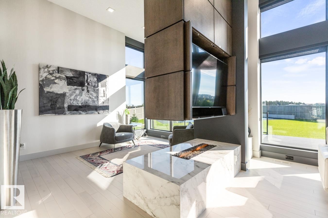 Main Floor Living Space featuring Floor to Ceiling Windows with Motorized Hunter Douglas Blinds, Opti-Myst Fireplace, and Custom Entertainment Unit. - 5536 Chegwin Point(E), Edmonton, AB - Indoor Photo Showing Other Room