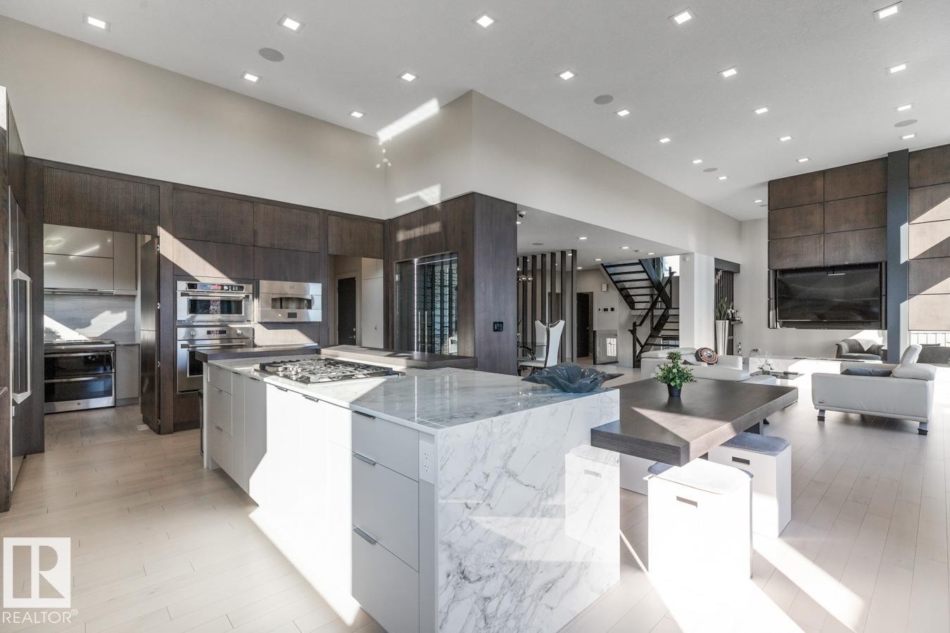 Stunning Kitchen featuring floor to ceiling windows with remote blinds, Gas Stove Top, Pizza Oven, Microwave Convection Oven, Oversized Refrigerator, Granite Counters, and Two Tone Cabinets. - 5536 Chegwin Point(E), Edmonton, AB - Indoor Photo Showing Kitchen With Upgraded Kitchen