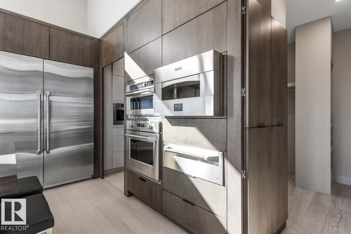 Stunning Kitchen featuring floor to ceiling windows with remote blinds, Gas Stove Top, Pizza Oven, Microwave Convection Oven, Oversized Refrigerator, Granite Counters, and Two Tone Cabinets. - 5536 Chegwin Point(E), Edmonton, AB - Indoor Photo Showing Kitchen