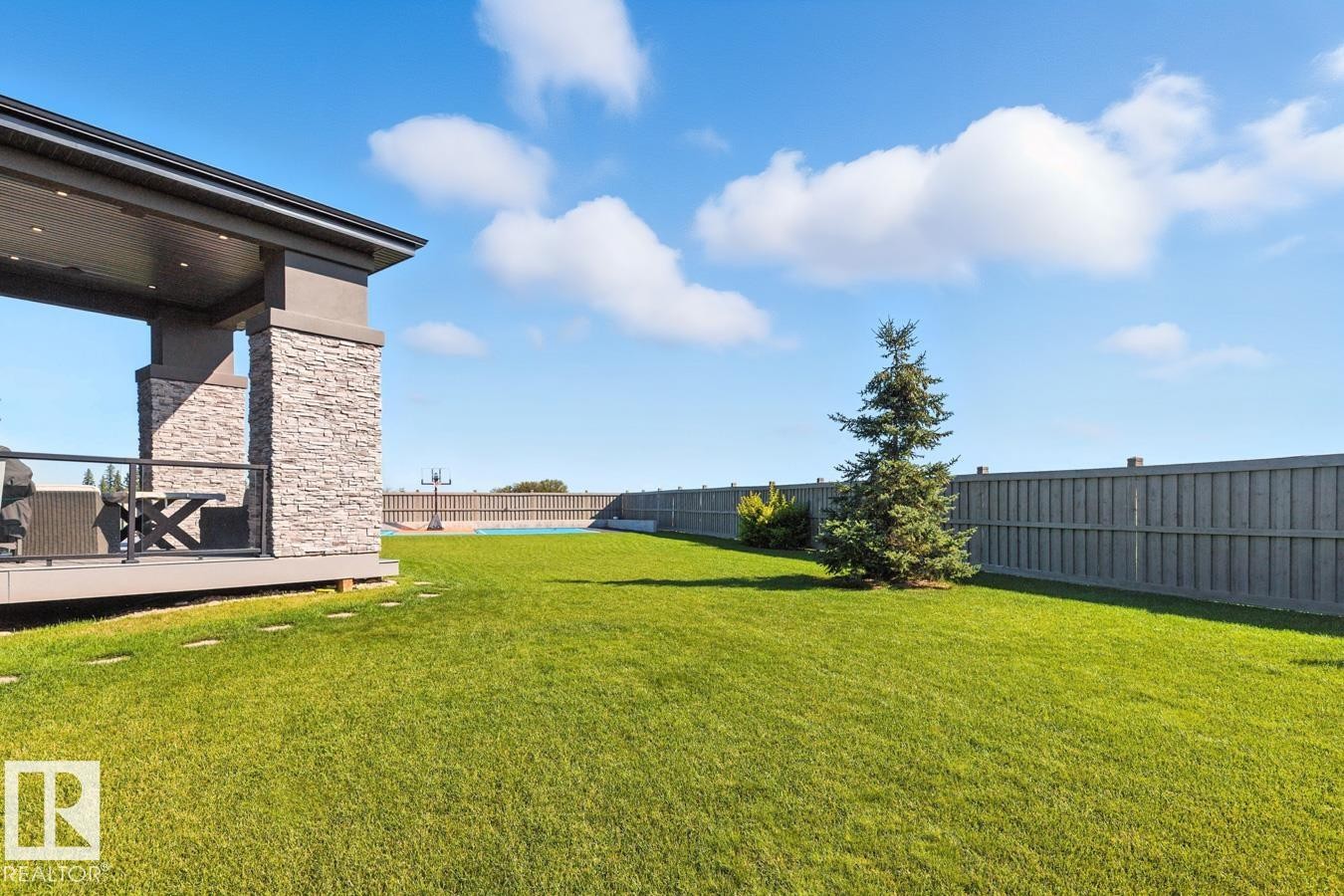 North East Facing Back yard featuring Covered Deck with Composite Boards, Ample Grass Space, Pickle Ball/Basketball Court, Fully Landscaped, and Fully Fenced. - 5536 Chegwin Point(E), Edmonton, AB - Outdoor