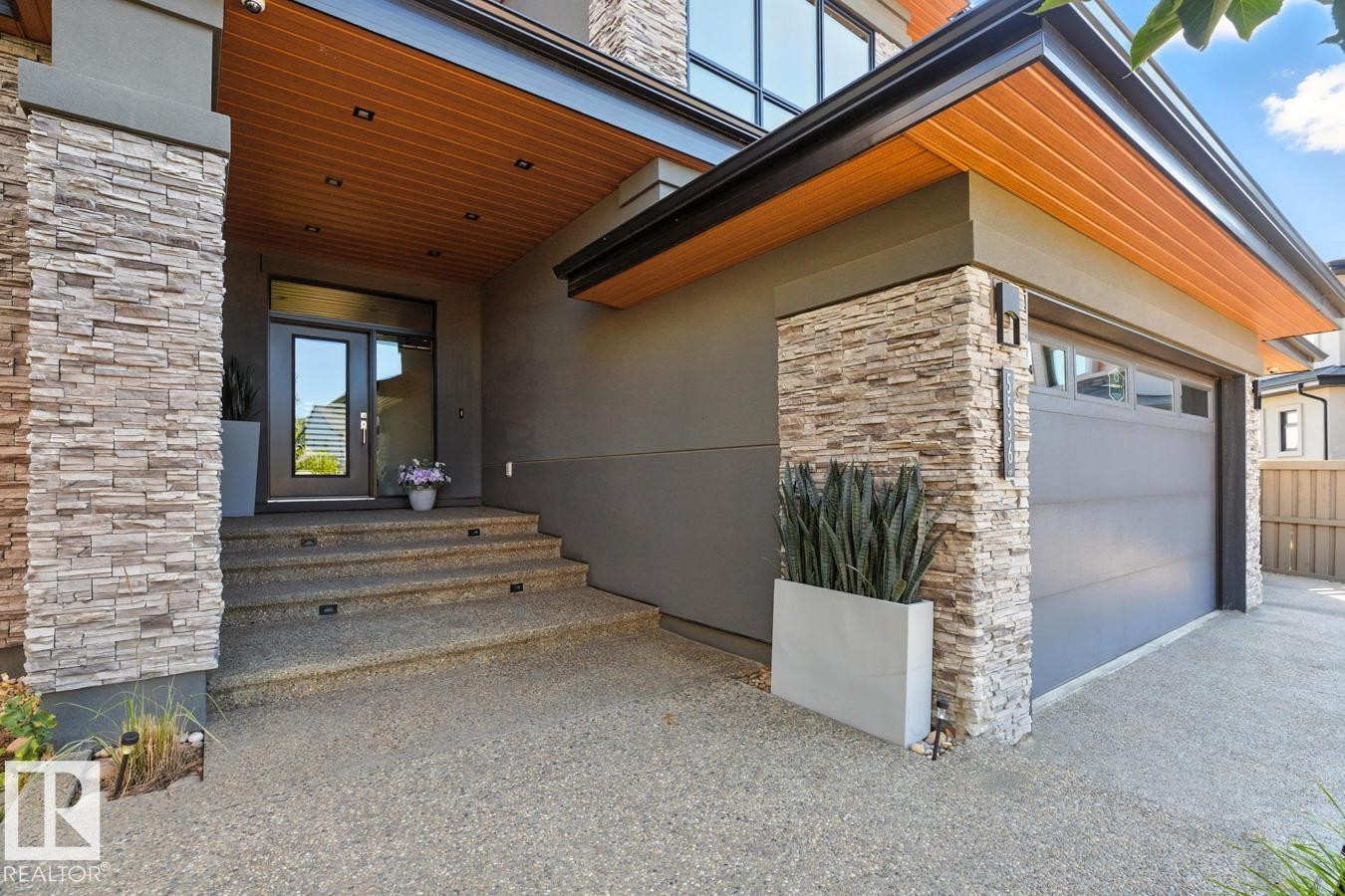 Exterior Front of House showing Oversized Driveway, Triple Car Garage, and Siding on to Walking Path - 5536 Chegwin Point(E), Edmonton, AB - Outdoor With Exterior