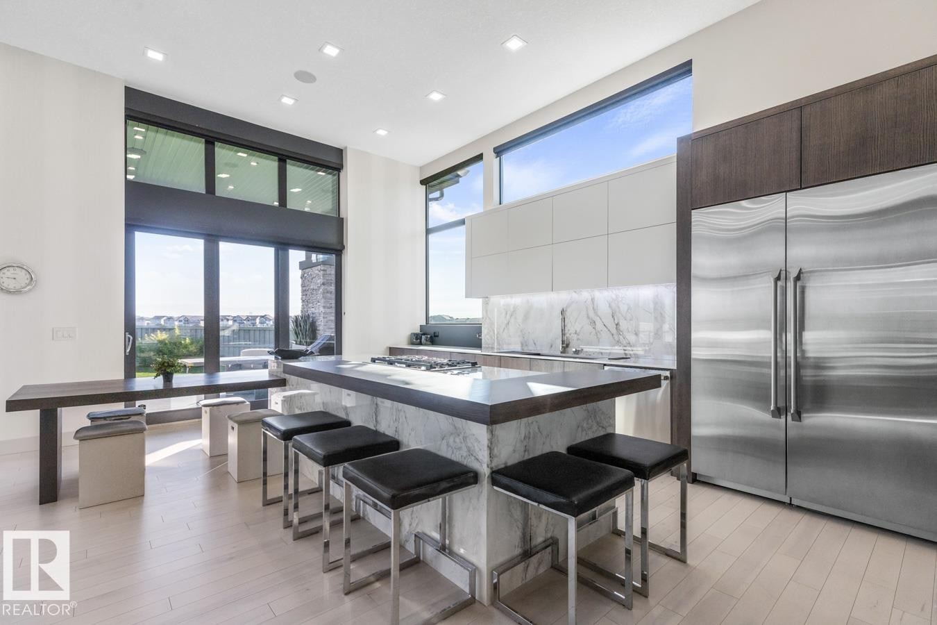 Stunning Kitchen featuring floor to ceiling windows with remote blinds, Gas Stove Top, Pizza Oven, Microwave Convection Oven, Oversized Refrigerator, Granite Counters, and Two Tone Cabinets. - 5536 Chegwin Point(E), Edmonton, AB - Indoor Photo Showing Dining Room