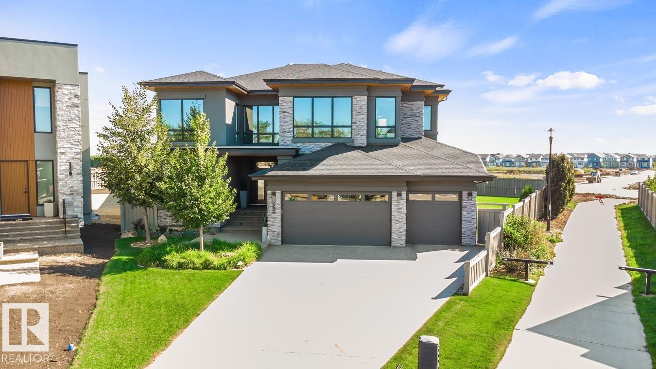 Exterior Front of House showing Oversized Driveway, Triple Car Garage, and Siding on to Walking Path - 5536 Chegwin Point(E), Edmonton, AB - Outdoor