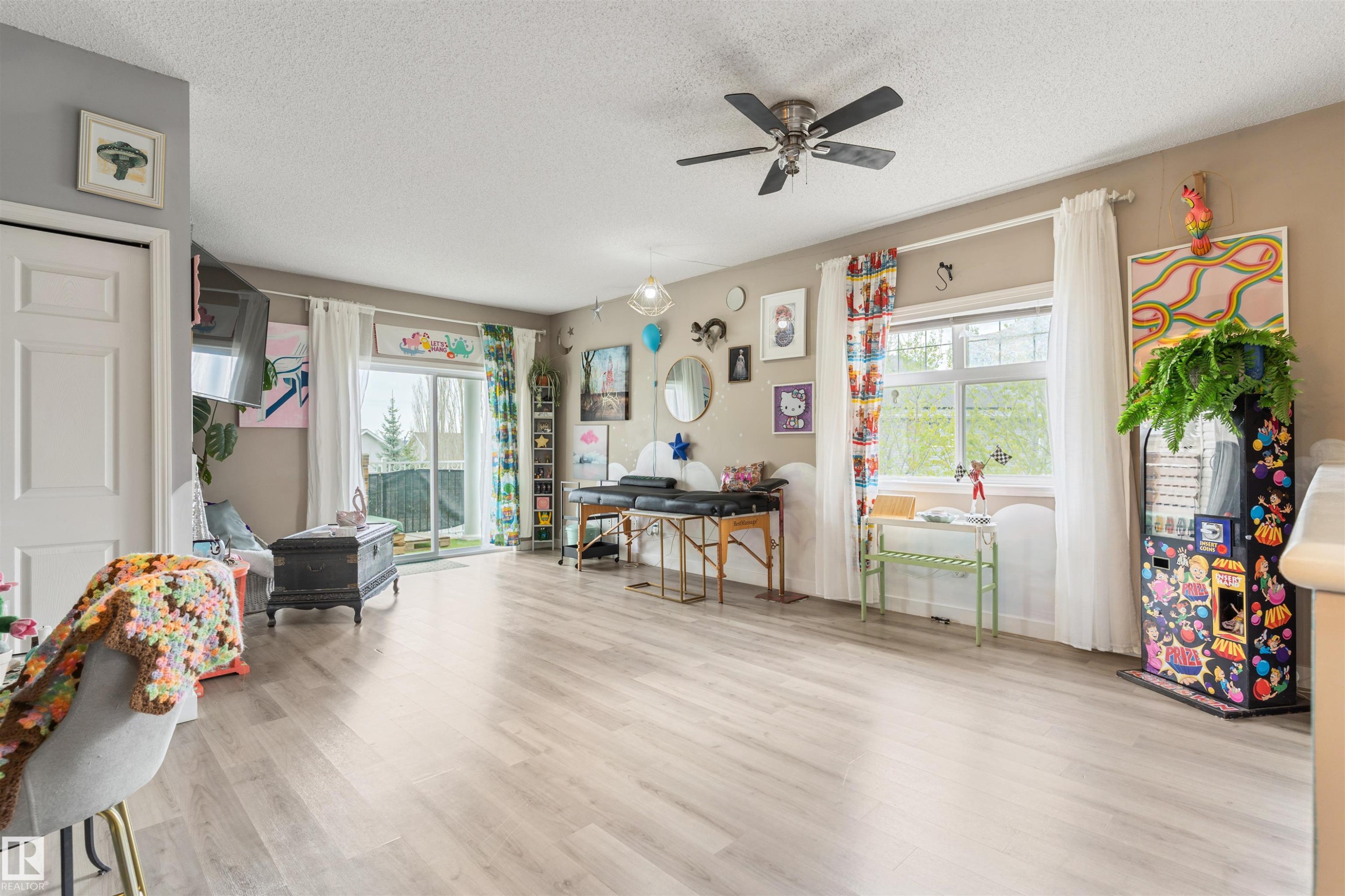 Spacious room featuring light wood-finish flooring, a ceiling fan with integrated lighting, and neutral wall tones - 73 3040 Spence Wynd, Edmonton, AB - Indoor