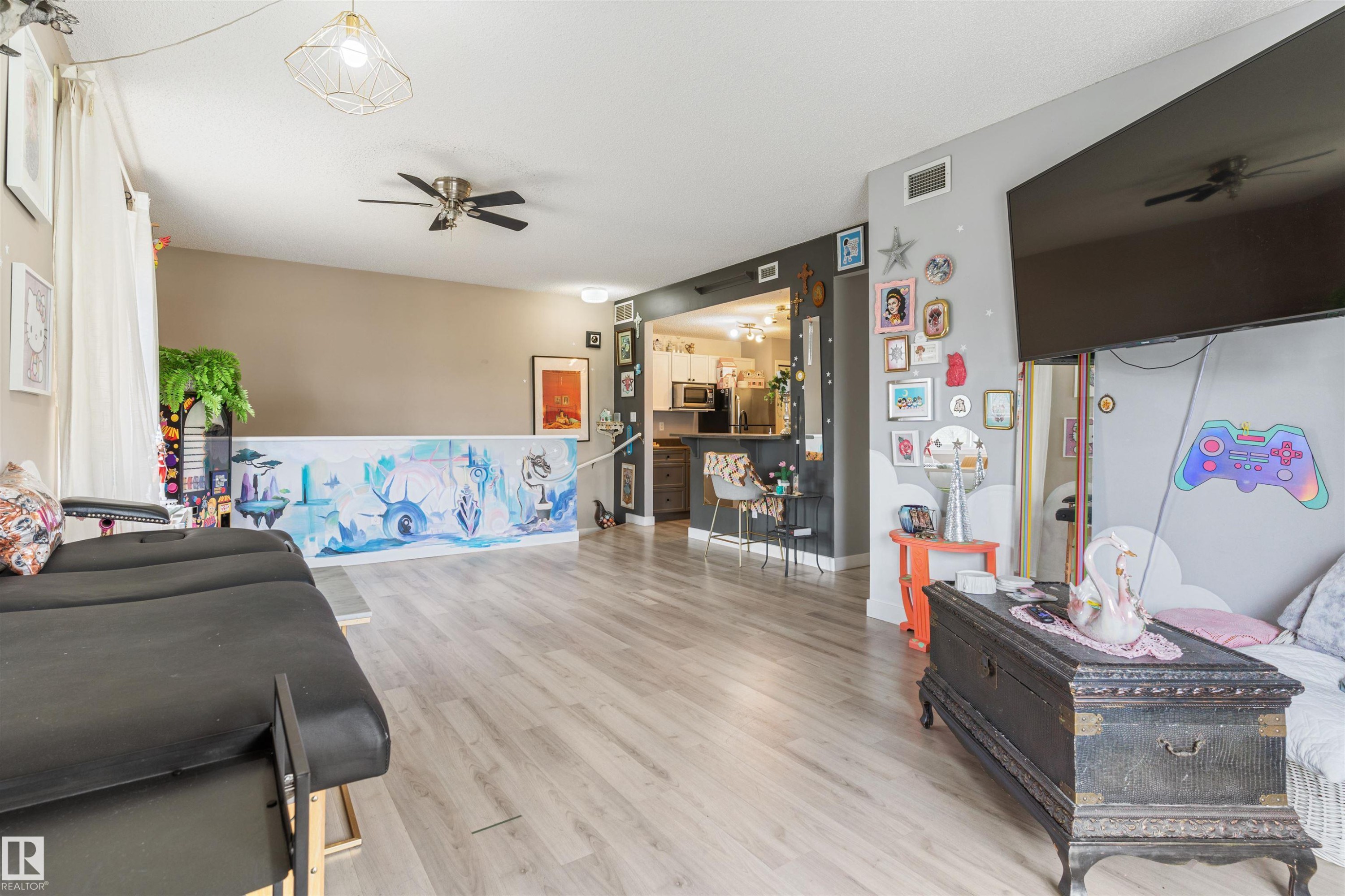 Open-concept living area featuring wood-finish flooring, recessed lighting, and a ceiling fan - 73 3040 Spence Wynd, Edmonton, AB - Indoor
