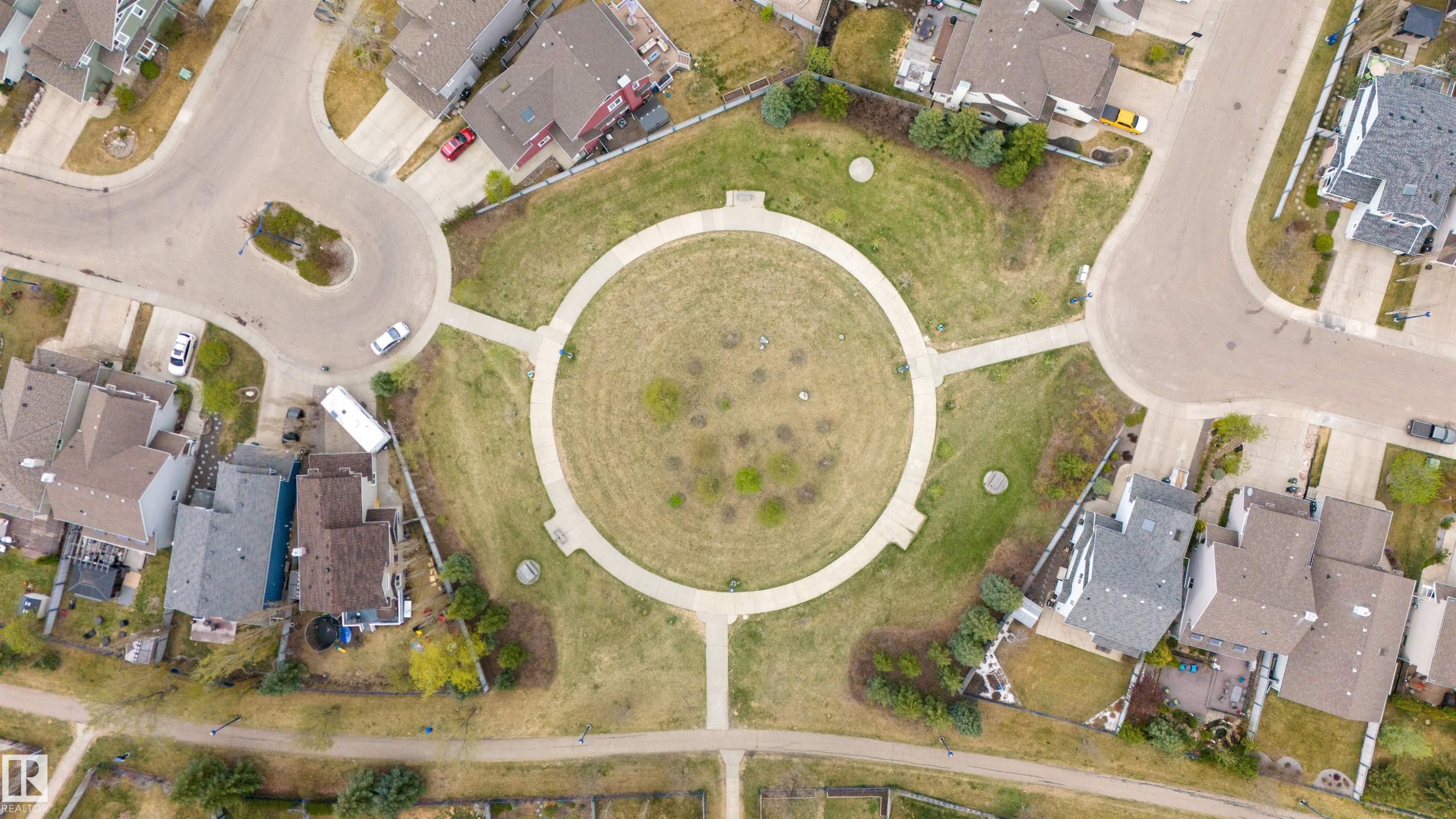 Circular park space with walking paths, surrounded by residential properties and paved streets - 73 3040 Spence Wynd, Edmonton, AB - Other