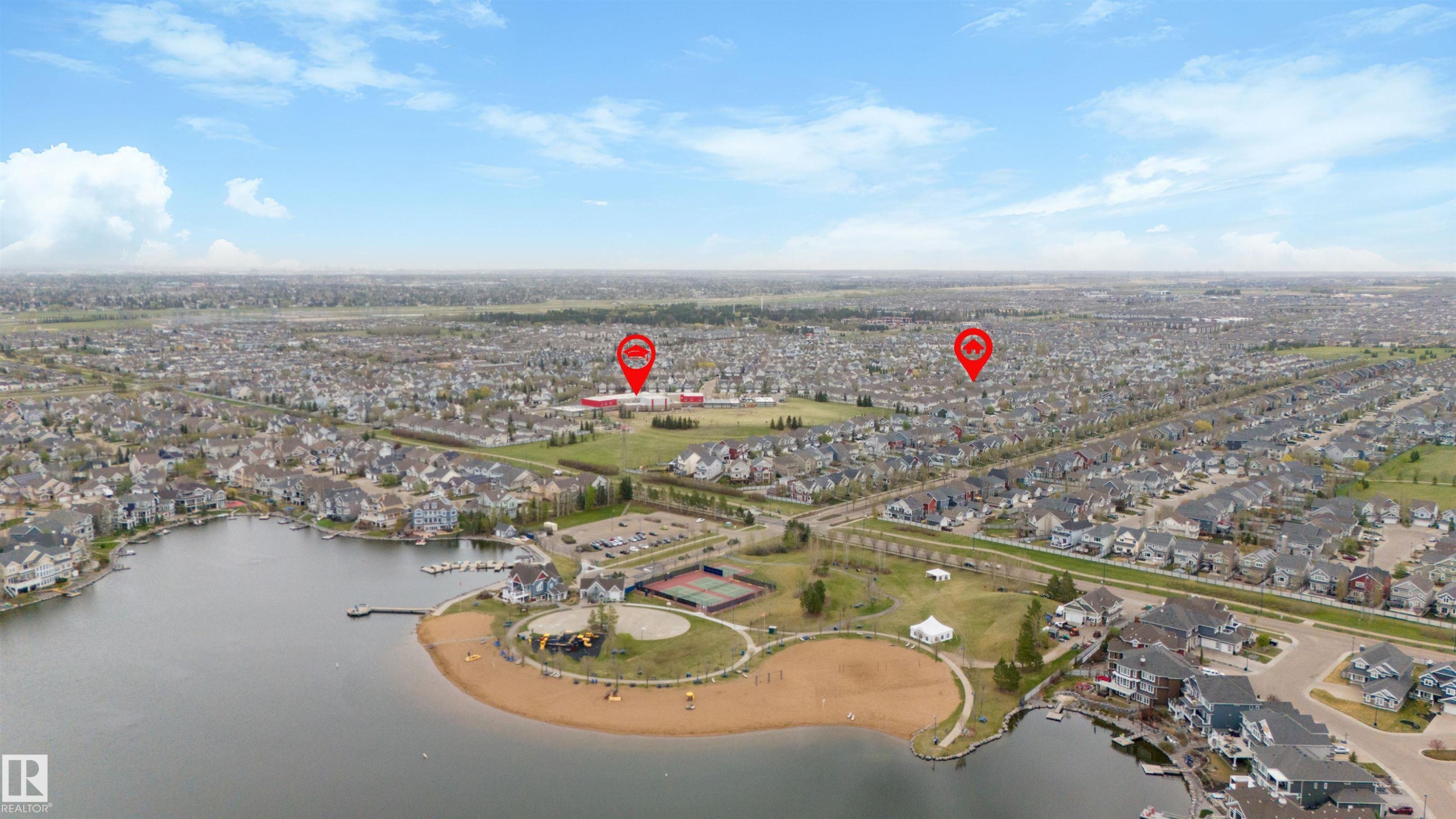 Aerial perspective showcasing a residential community with a large central lake - 73 3040 Spence Wynd, Edmonton, AB - Outdoor With Body Of Water With View