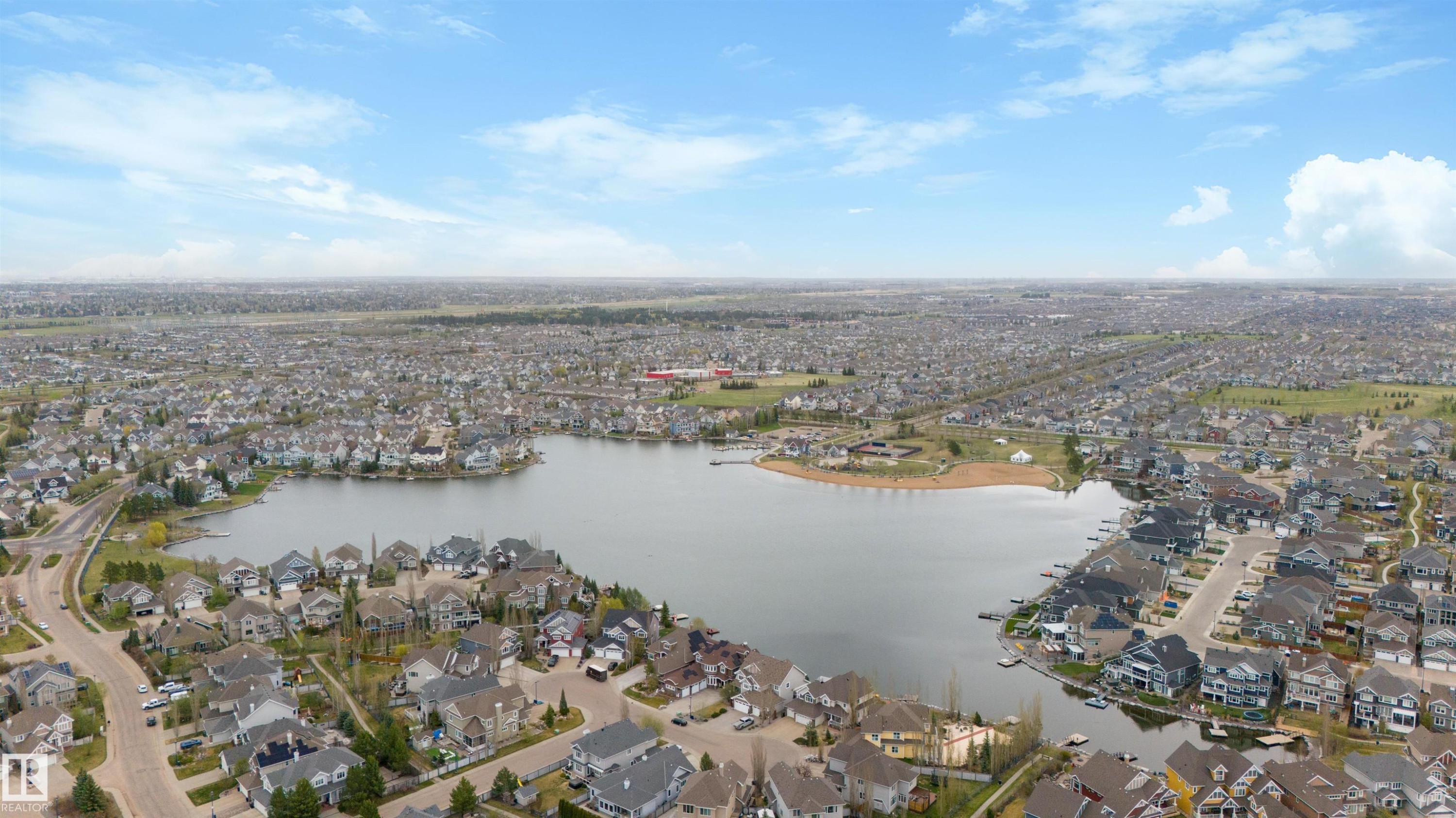 Aerial perspective showcasing a residential area featuring a central lake - 73 3040 Spence Wynd, Edmonton, AB - Outdoor With Body Of Water With View