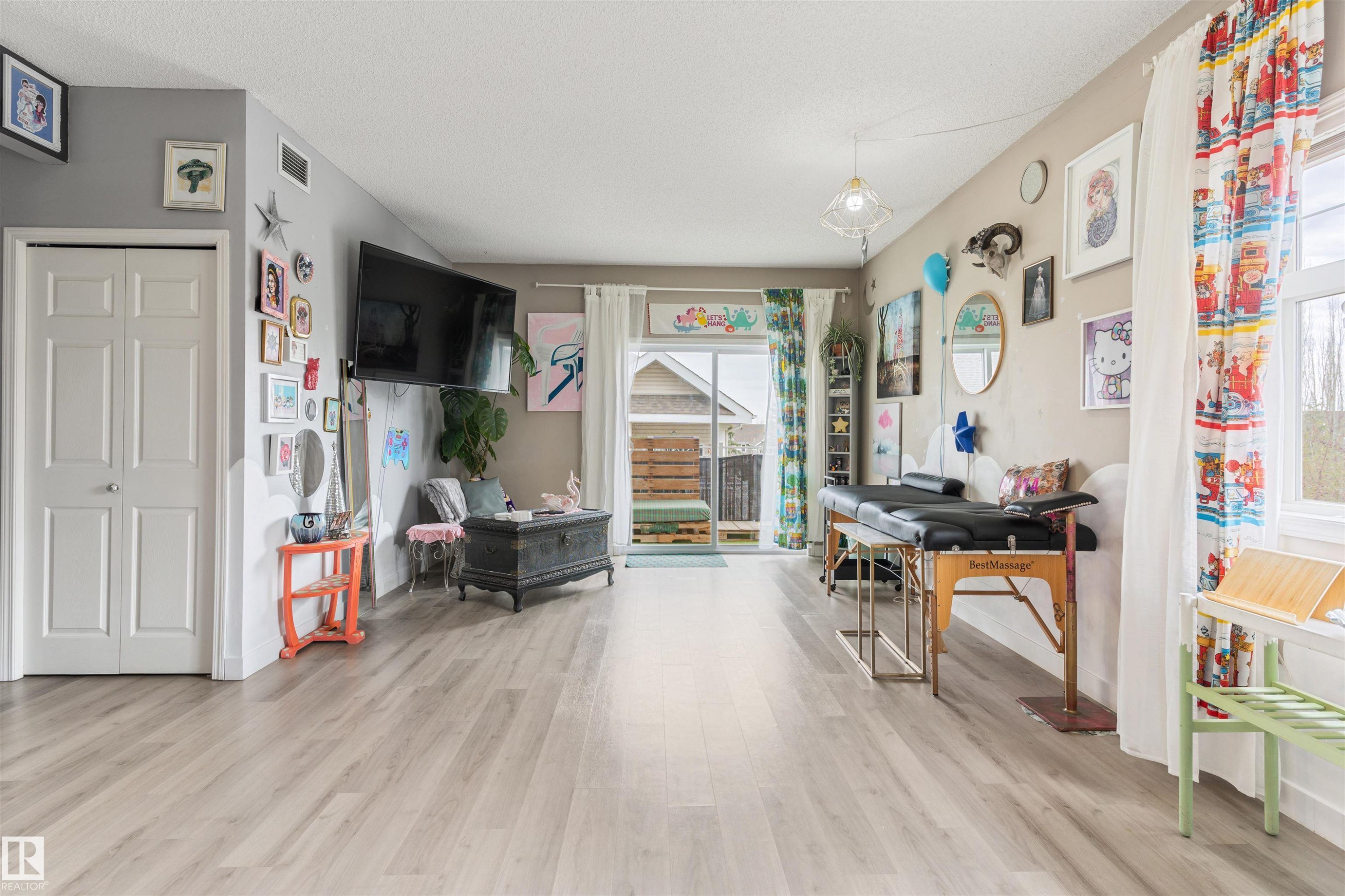 Spacious room featuring light wood-finish flooring, a neutral wall palette, and multiple windows for natural illumination - 73 3040 Spence Wynd, Edmonton, AB - Indoor