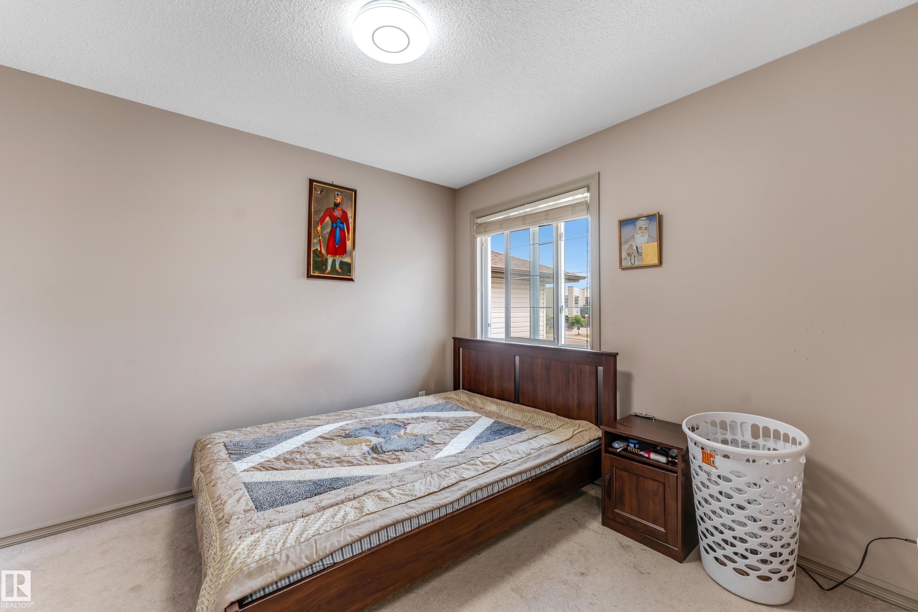 The property features a bedroom with a window, carpeting, and light-colored walls - 463 Tamarack Green, Edmonton, AB - Indoor Photo Showing Bedroom