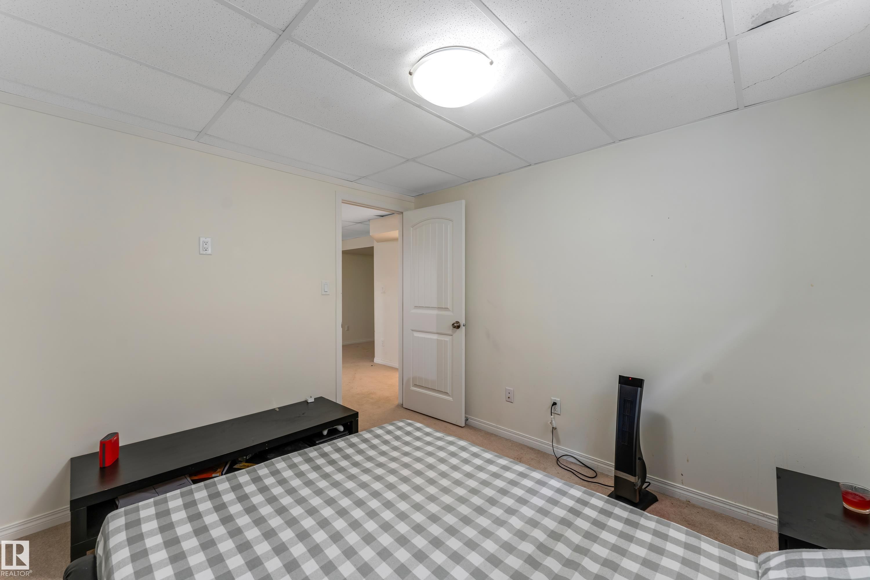 The room features a neutral color palette, carpeted flooring, and a drop ceiling with recessed lighting - 463 Tamarack Green, Edmonton, AB - Indoor Photo Showing Bedroom