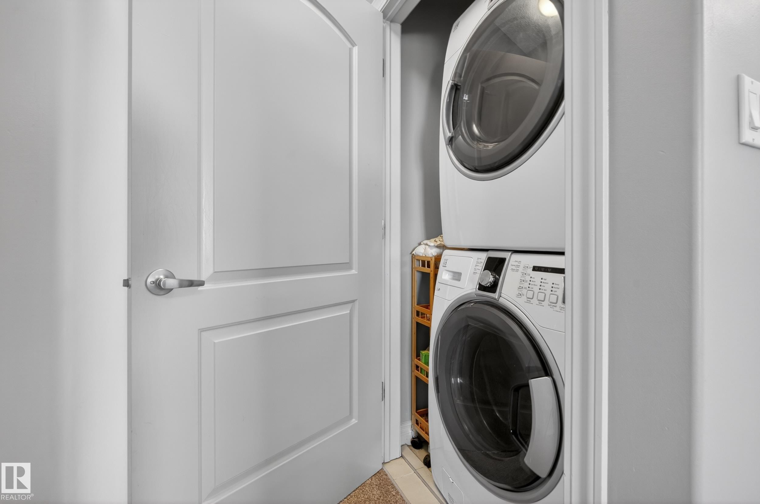 Dedicated laundry closet featuring a stacked washer and dryer - 7074 Cardinal Way, Edmonton, AB - Indoor Photo Showing Laundry Room