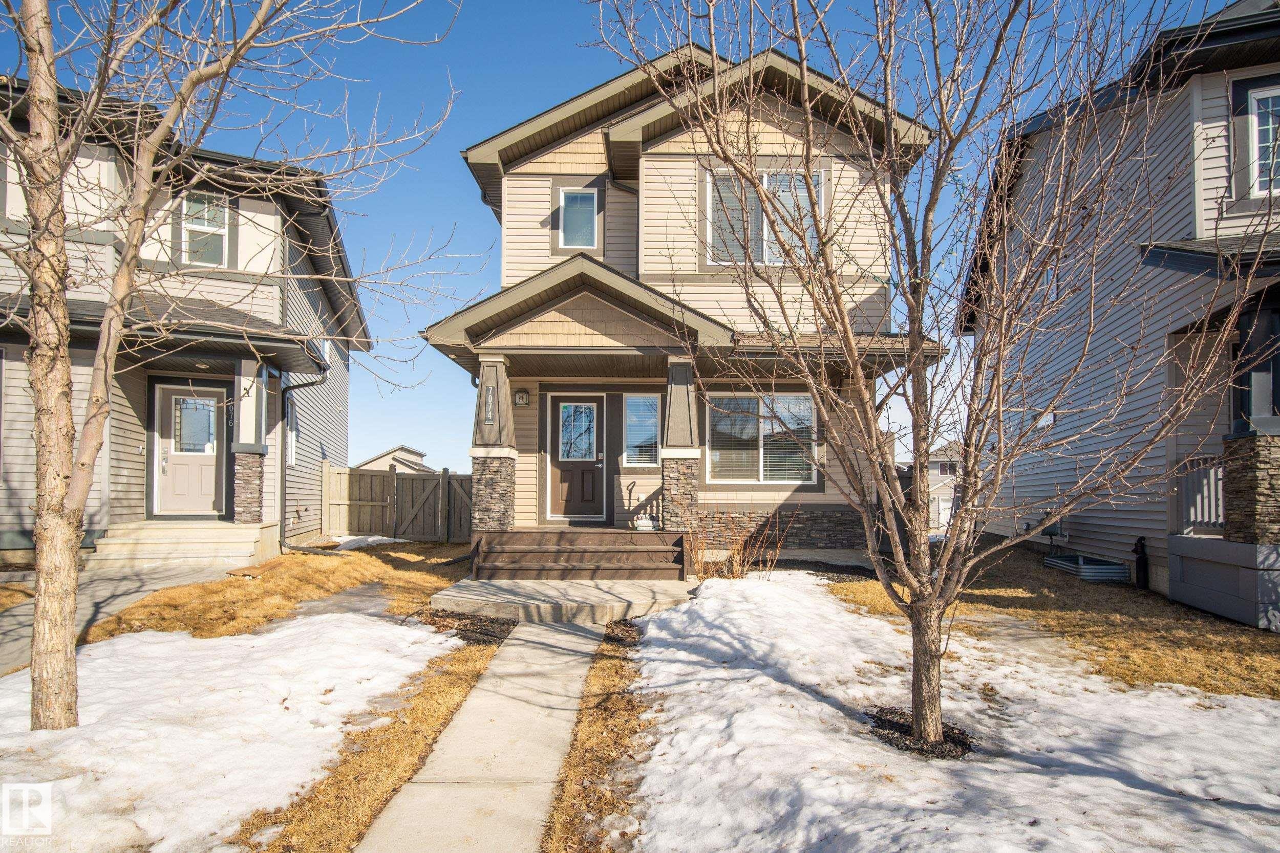 Two-story residence featuring light-colored siding and stone accents on the facade - 7074 Cardinal Way, Edmonton, AB - Outdoor With Facade