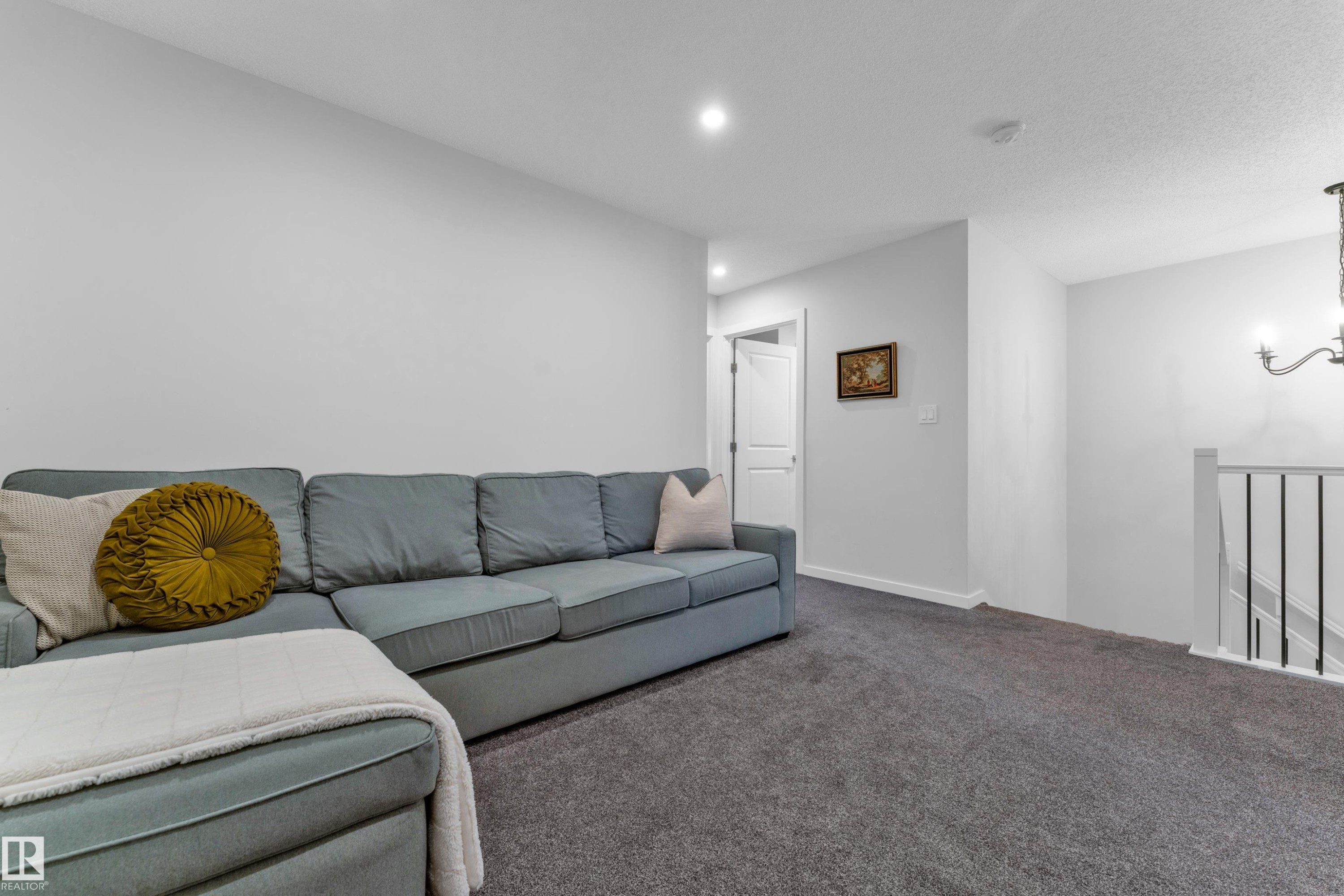 Carpeted recreation room featuring recessed lighting and a white interior door - 17319 2 St Nw, Edmonton, AB - Indoor Photo Showing Living Room