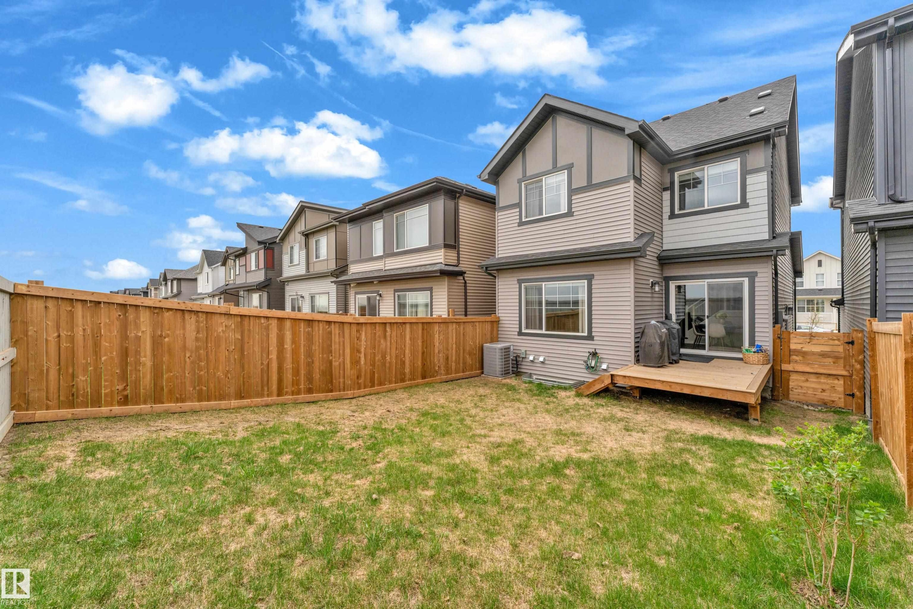 Private backyard featuring a natural wood fence and a ground-level wood deck - 17319 2 St Nw, Edmonton, AB - Outdoor