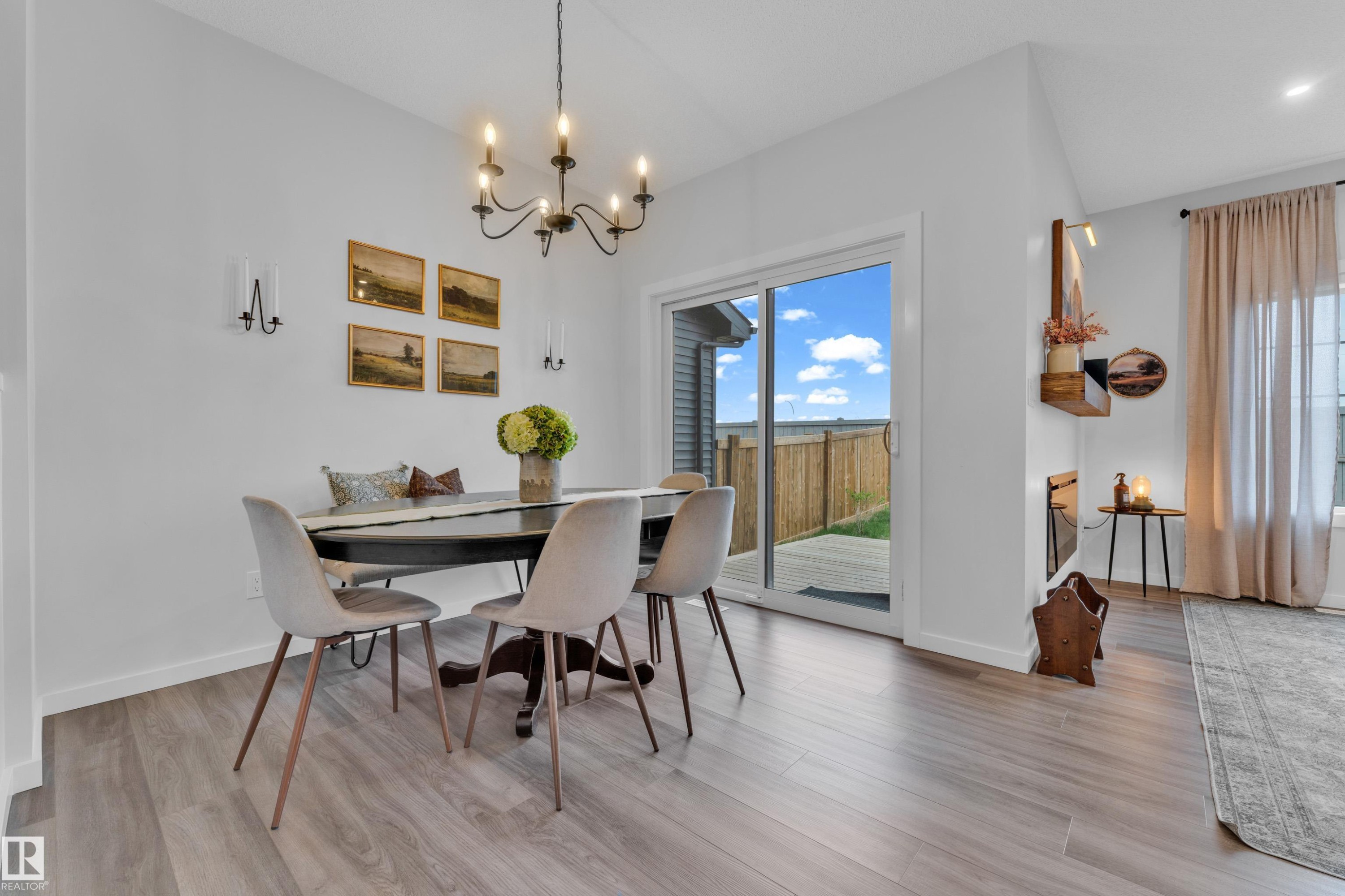 Bright open concept living area featuring wood-finish flooring, a contemporary chandelier, and recessed lighting - 17319 2 St Nw, Edmonton, AB - Indoor Photo Showing Dining Room