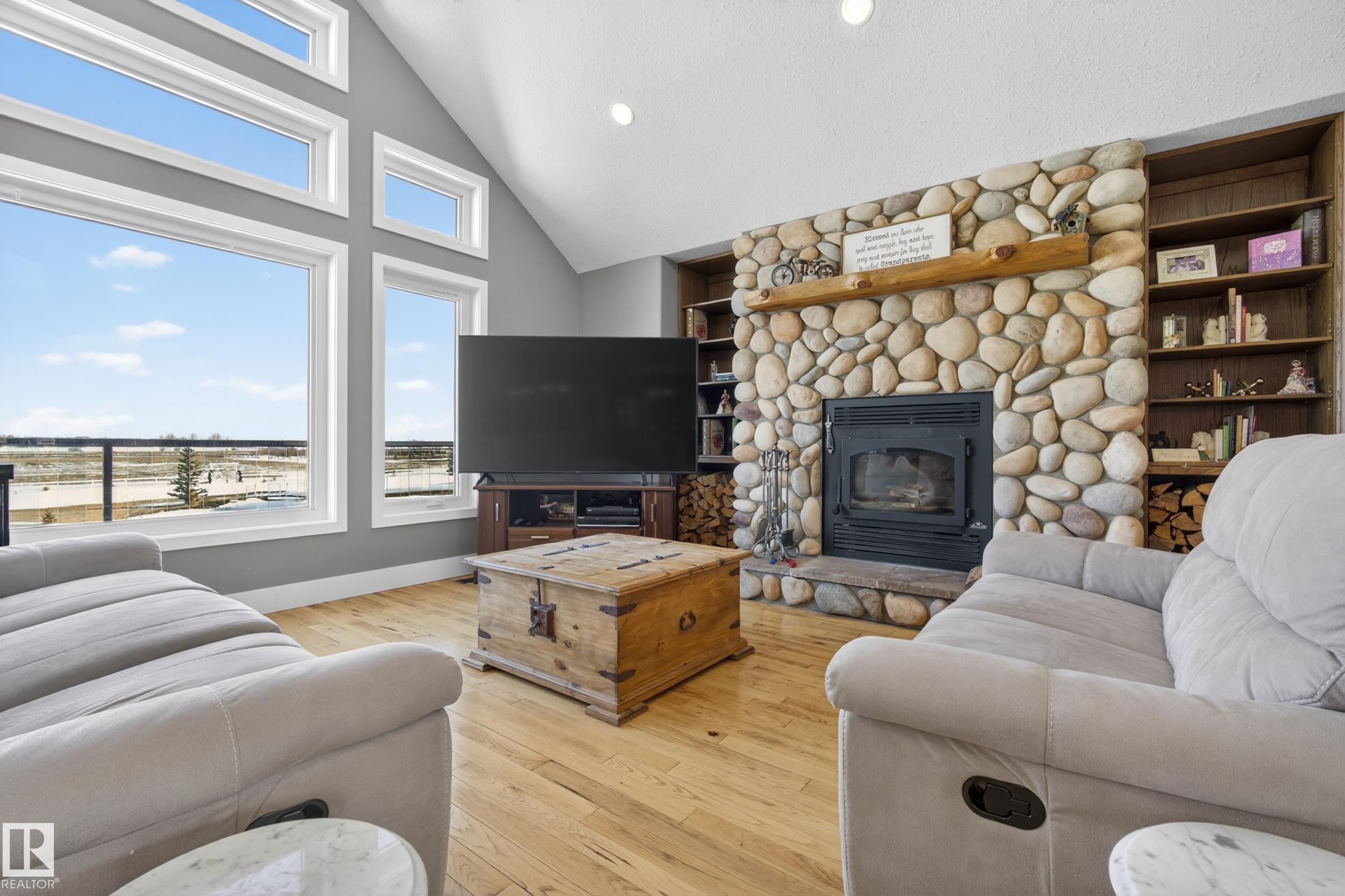 Living area featuring a stone fireplace with a wooden mantel and built-in shelving - 531064 Range Road 174, Rural Lamont County, AB - Indoor Photo Showing Living Room With Fireplace